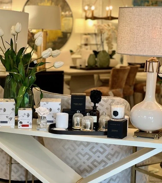 Decorative table with flowers, candles, and luxury items in a home interior.