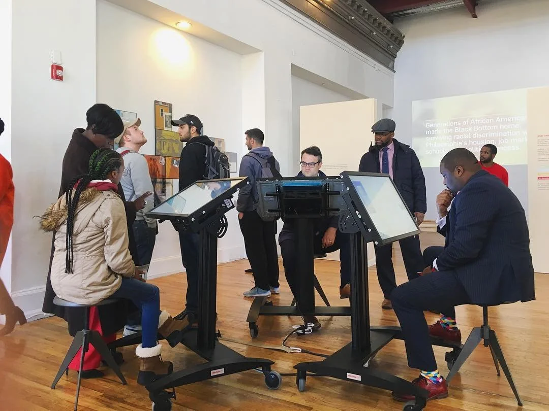 People in a museum viewing historical displays and digital exhibits.