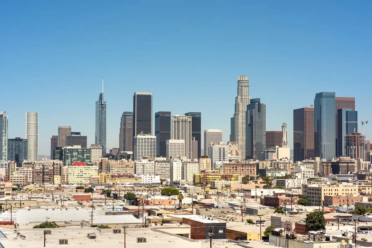 Los Angeles skyline with tall skyscrapers and a clear blue sky.