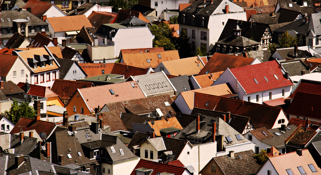 Aerial view of a densely packed neighborhood with various colorful rooftops and houses.