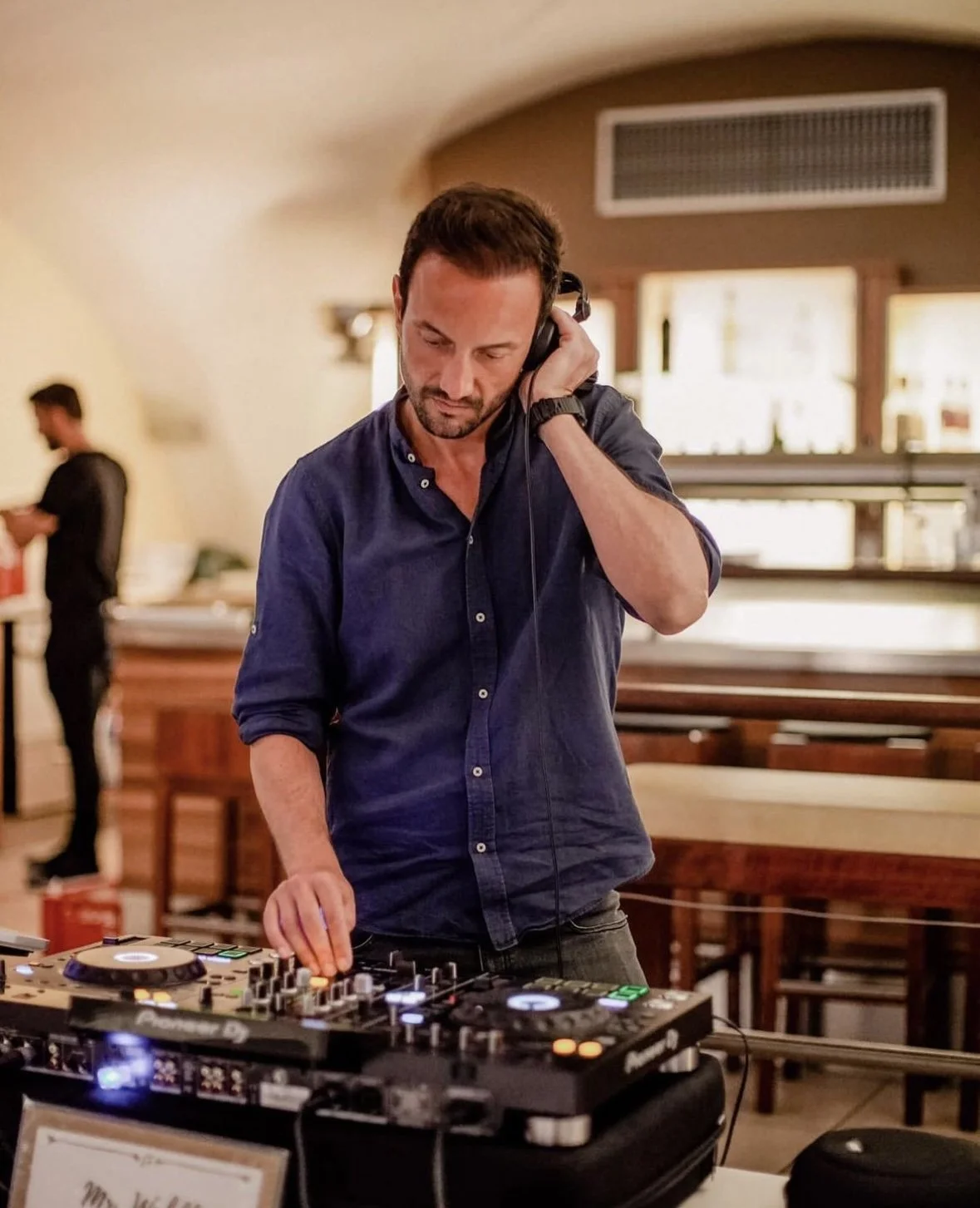 DJ Mister Wulff am Pult bei einer Veranstaltung mit Kopfhörer