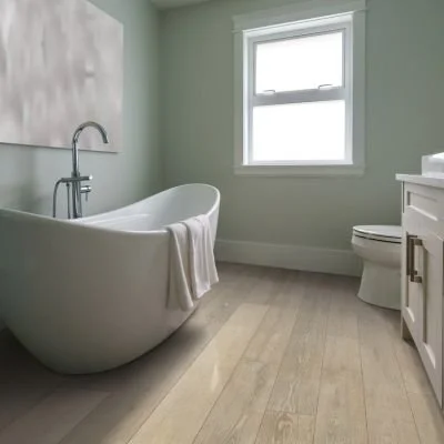 Empty bathroom with a freestanding bathtub, a window, a toilet, and a white vanity