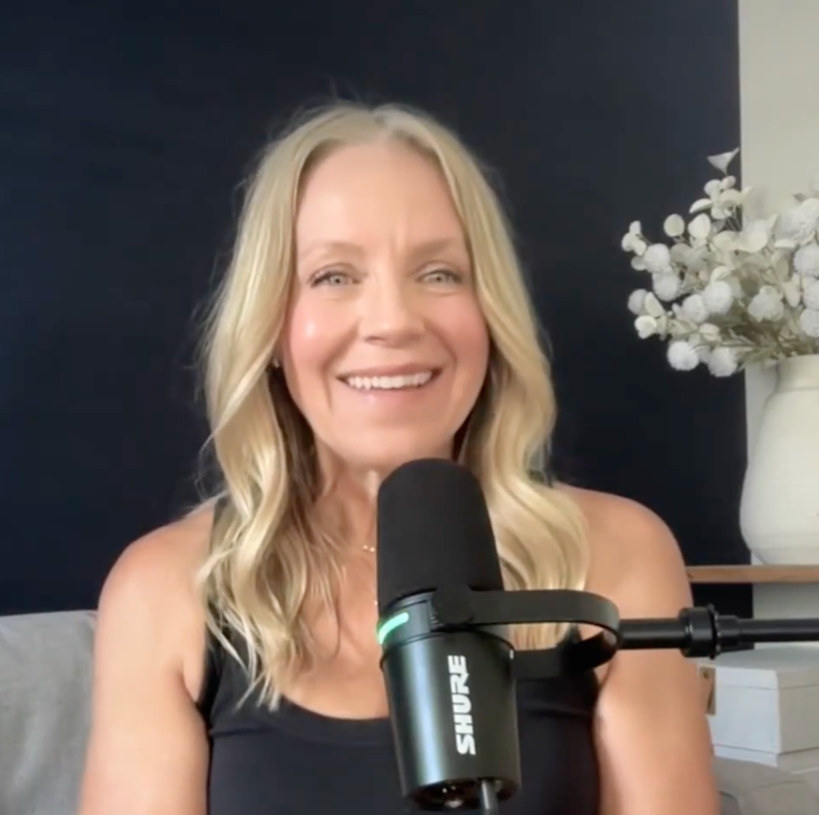 Angie Mizzell in front of her microphone during a podcast interview.