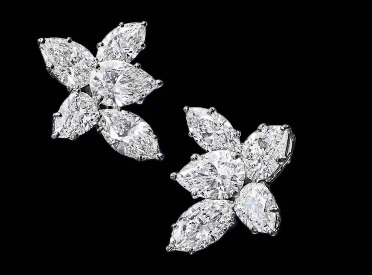 A pair of diamond butterfly-shaped earrings with black background.