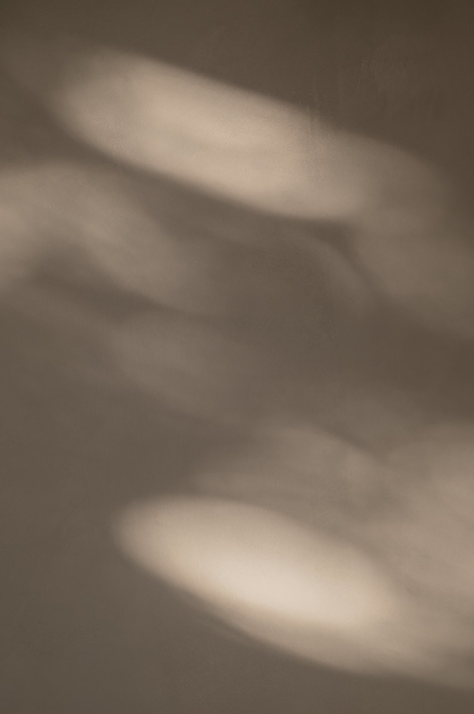 Blurred abstract image with soft light and shadow, no distinct objects visible.