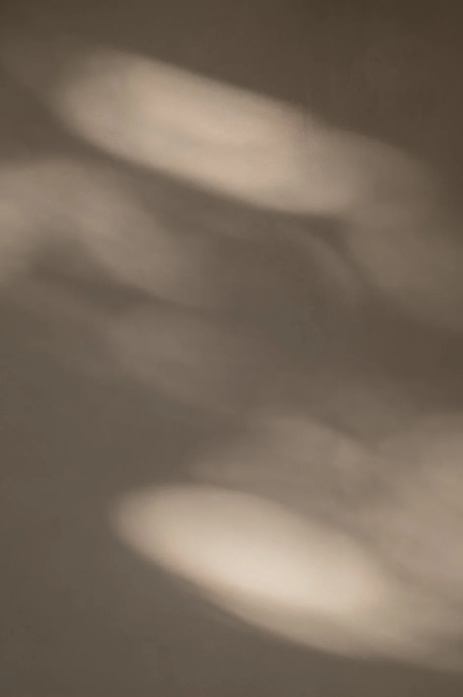 Blurred and shadowed close-up of a surface or fabric with soft light and shadows.