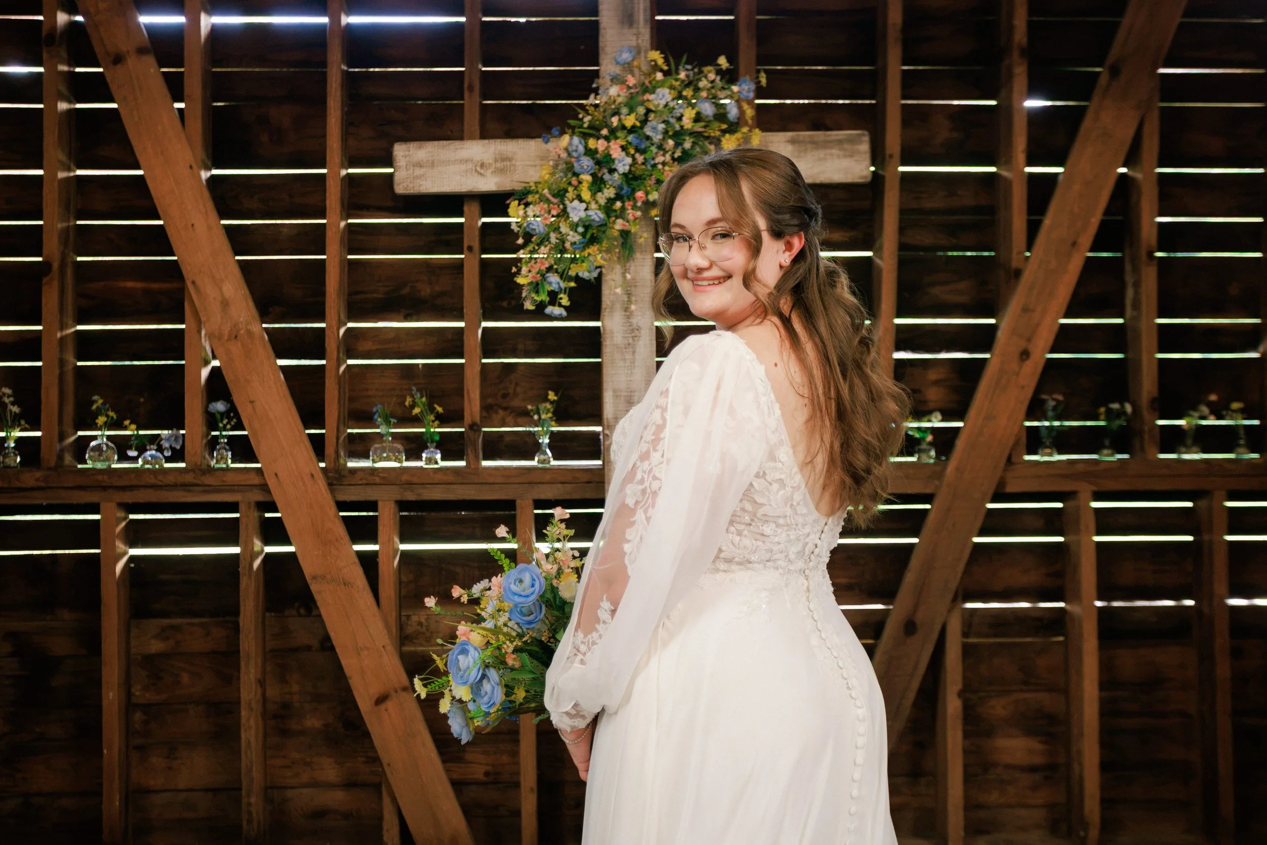 Bride looking back at the camera in front of a cross.