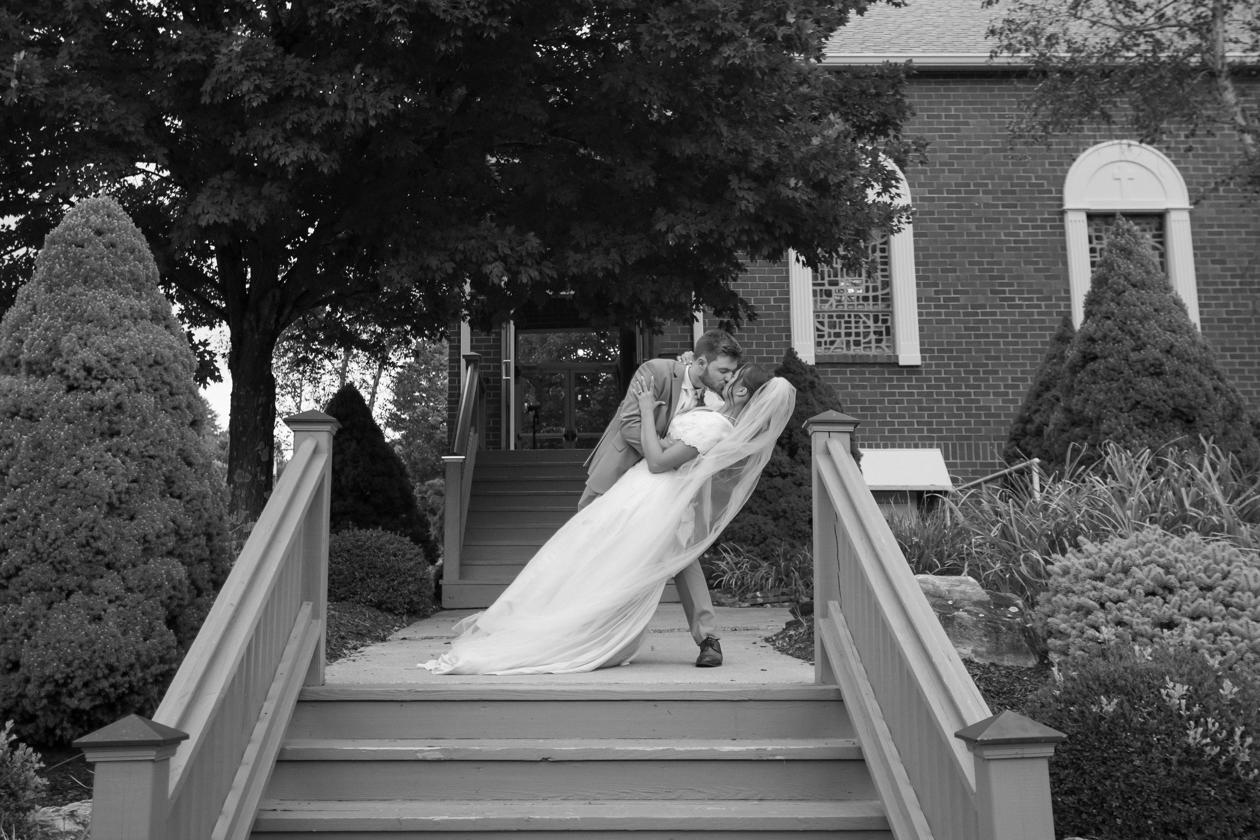 Bride and groom kissing while dipping