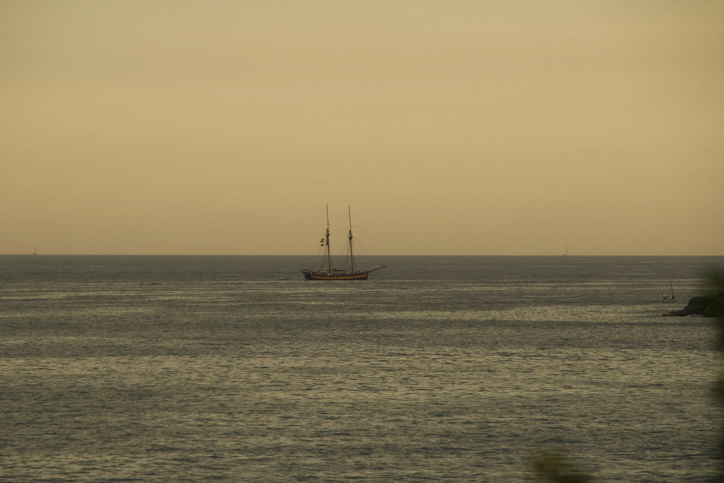 Mediterranean seascape on the Costa Brava with a traditional sailing boat, photographed as part of the relaxed Pietro SS26 summer fashion story.