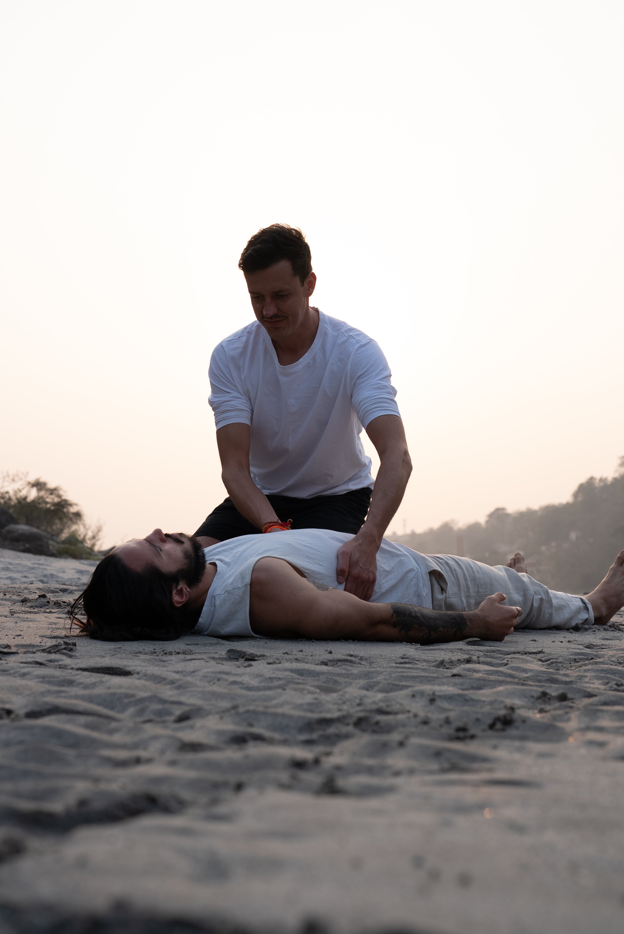 Zwei Männer praktizieren während einer Breathwork-Session die Co-Regulation des Nervensystems.