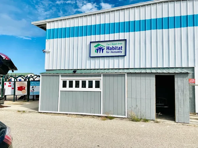 Exterior of a Habitat for Humanity storage or donation center building with a sign that reads "Fort Hood Area Habitat for Humanity"