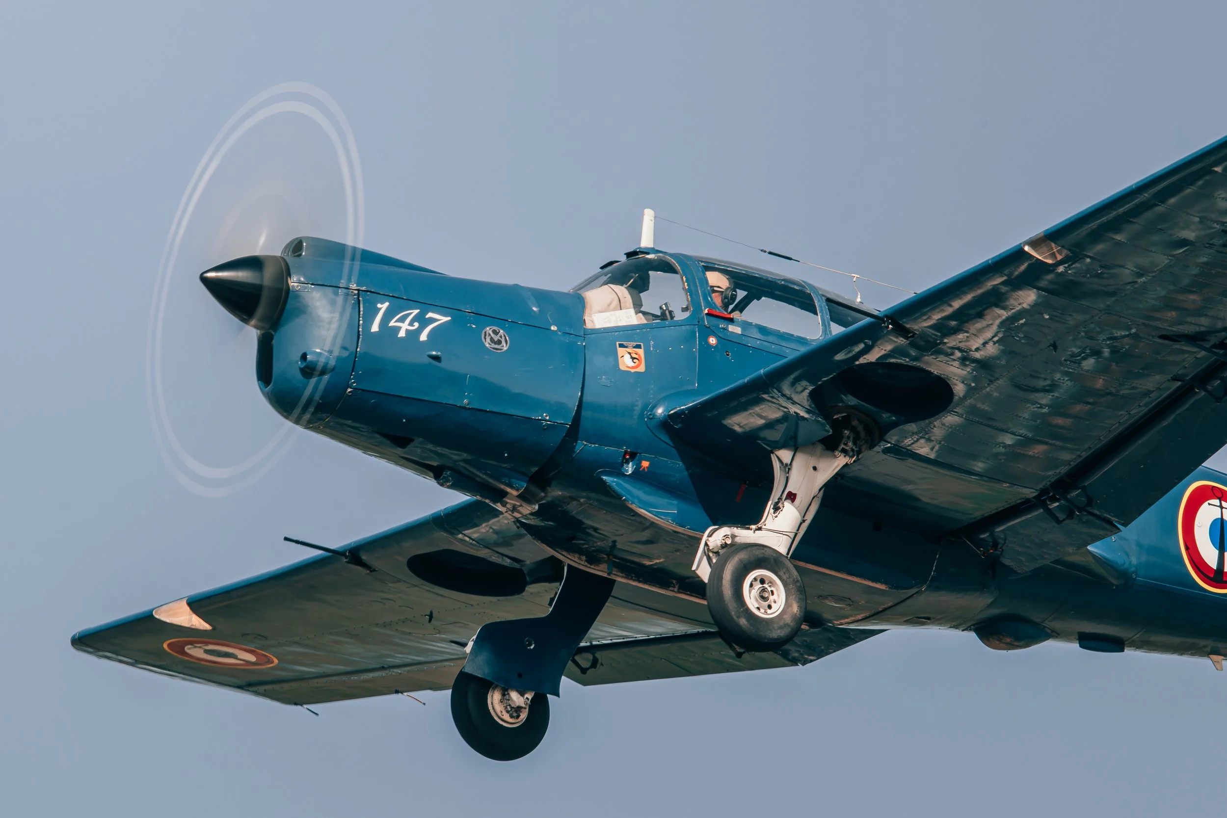Un avion de chasse en vol, vue latérale, ciel clair.