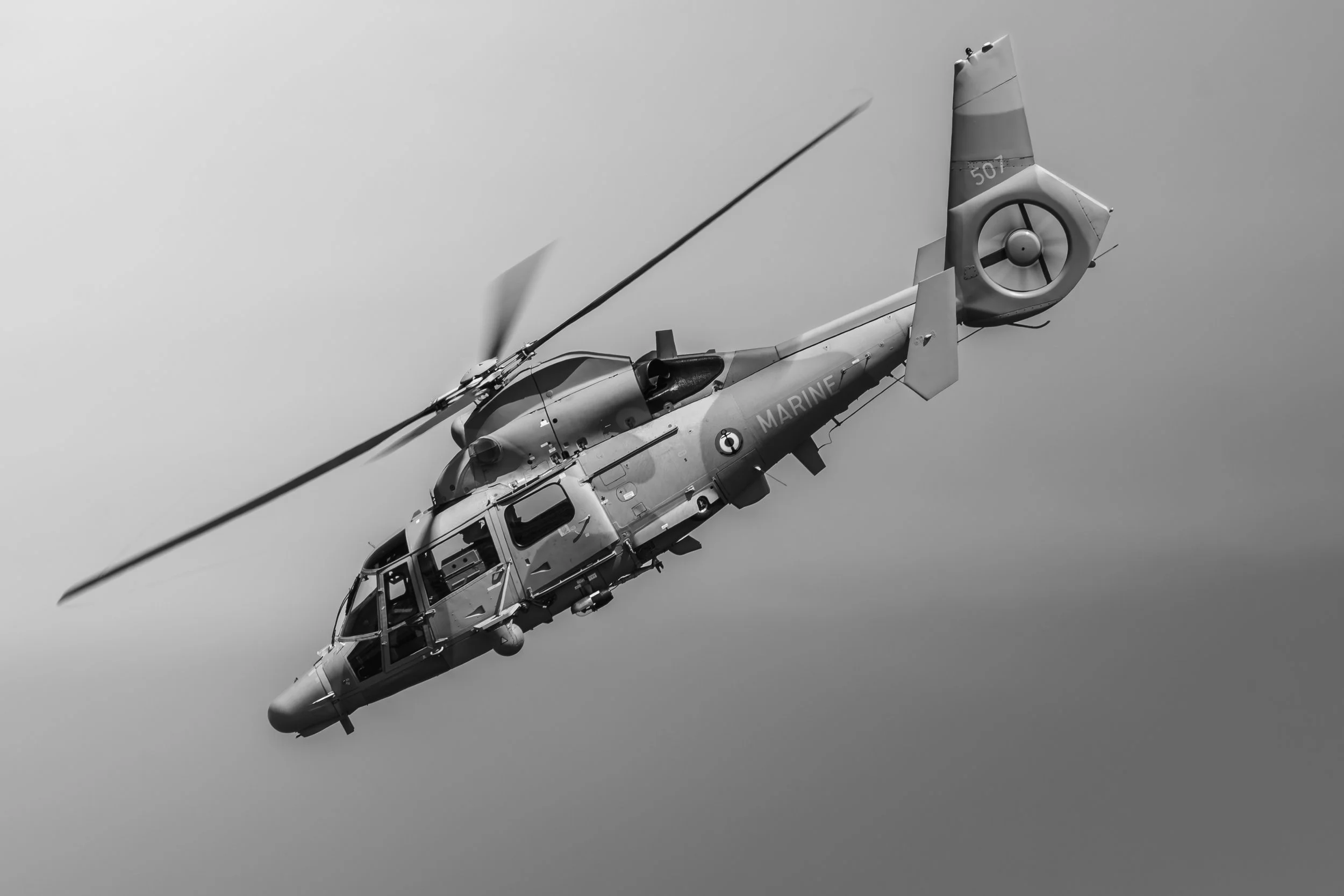 Un hélicoptère militaire en vol dans le ciel.}