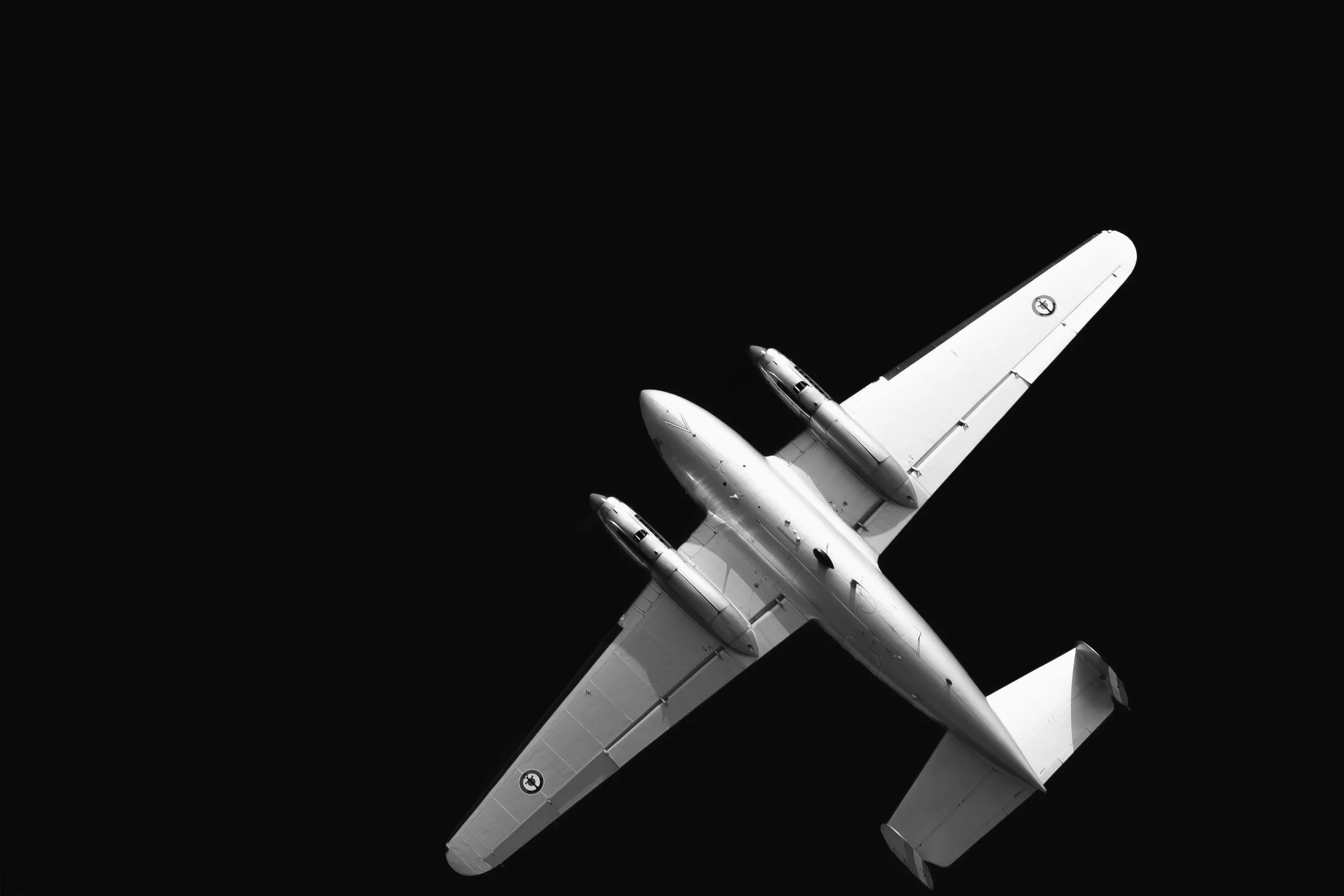 Avion de ligne blanc vu du dessous dans l'espace noir.