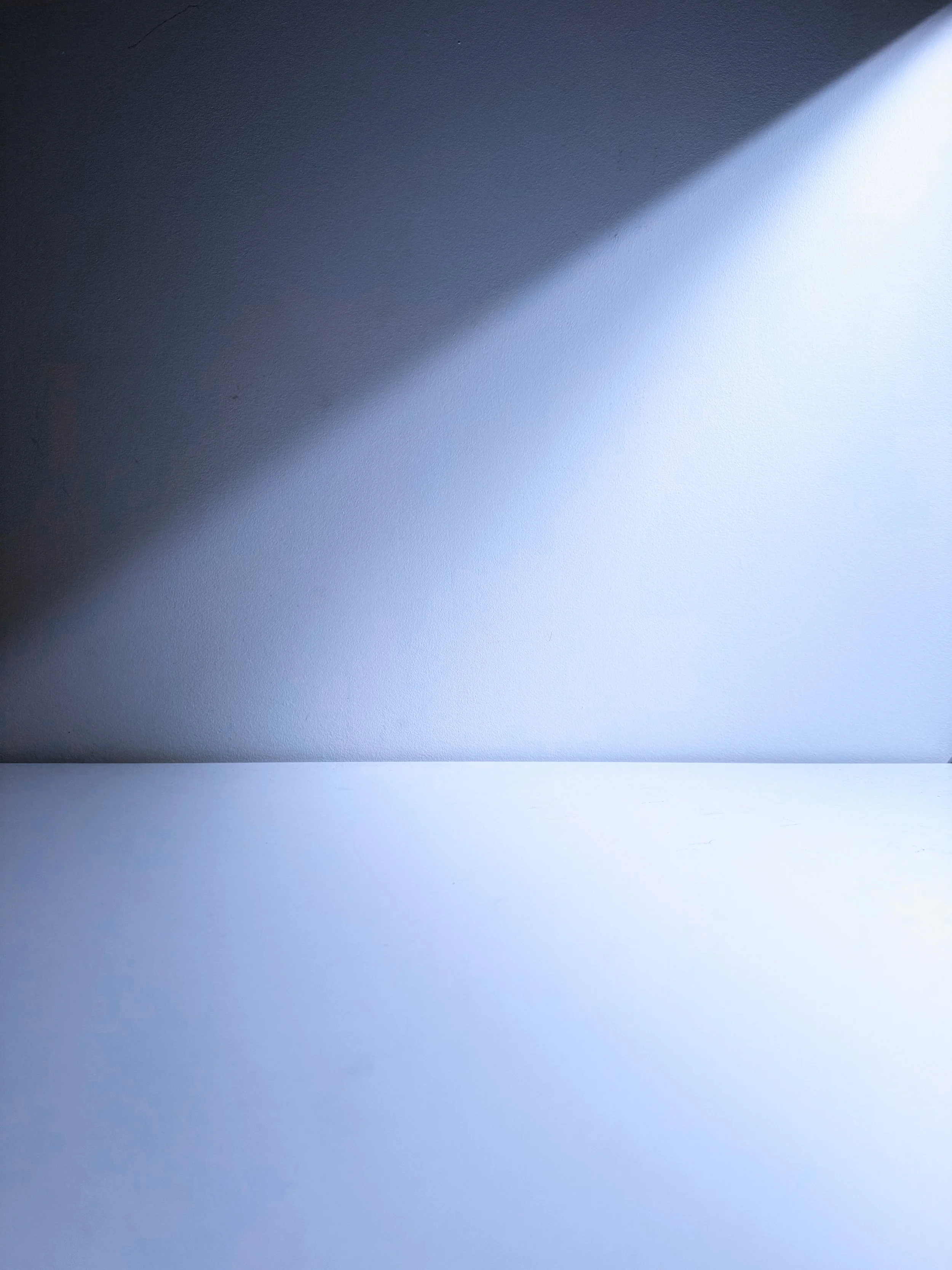 Abstract image with a gradient of dark blue to light blue and a diagonal band of light.
