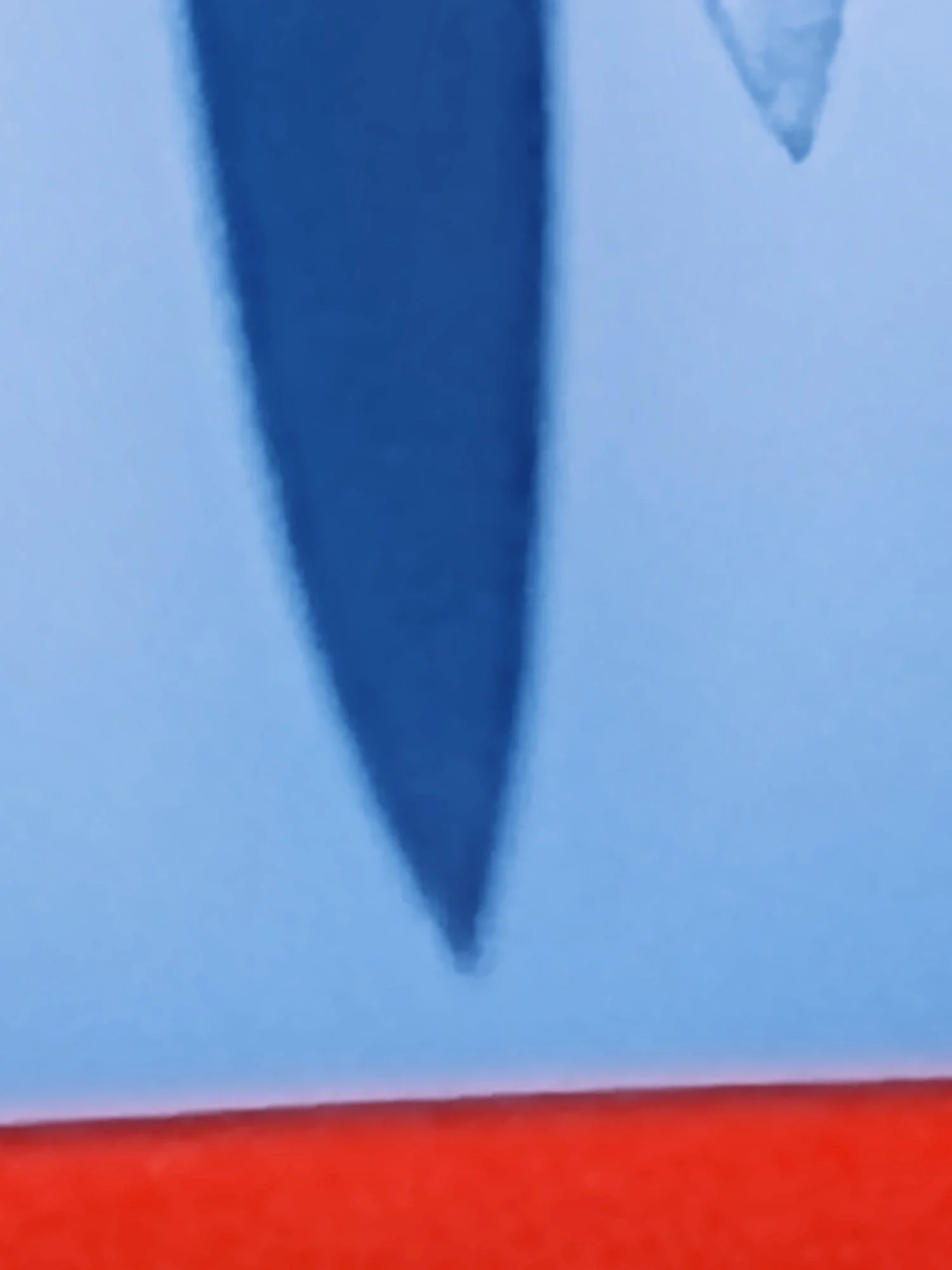 Close-up of an American flag blowing in the wind, showing part of the blue field with a star and red and white stripes.