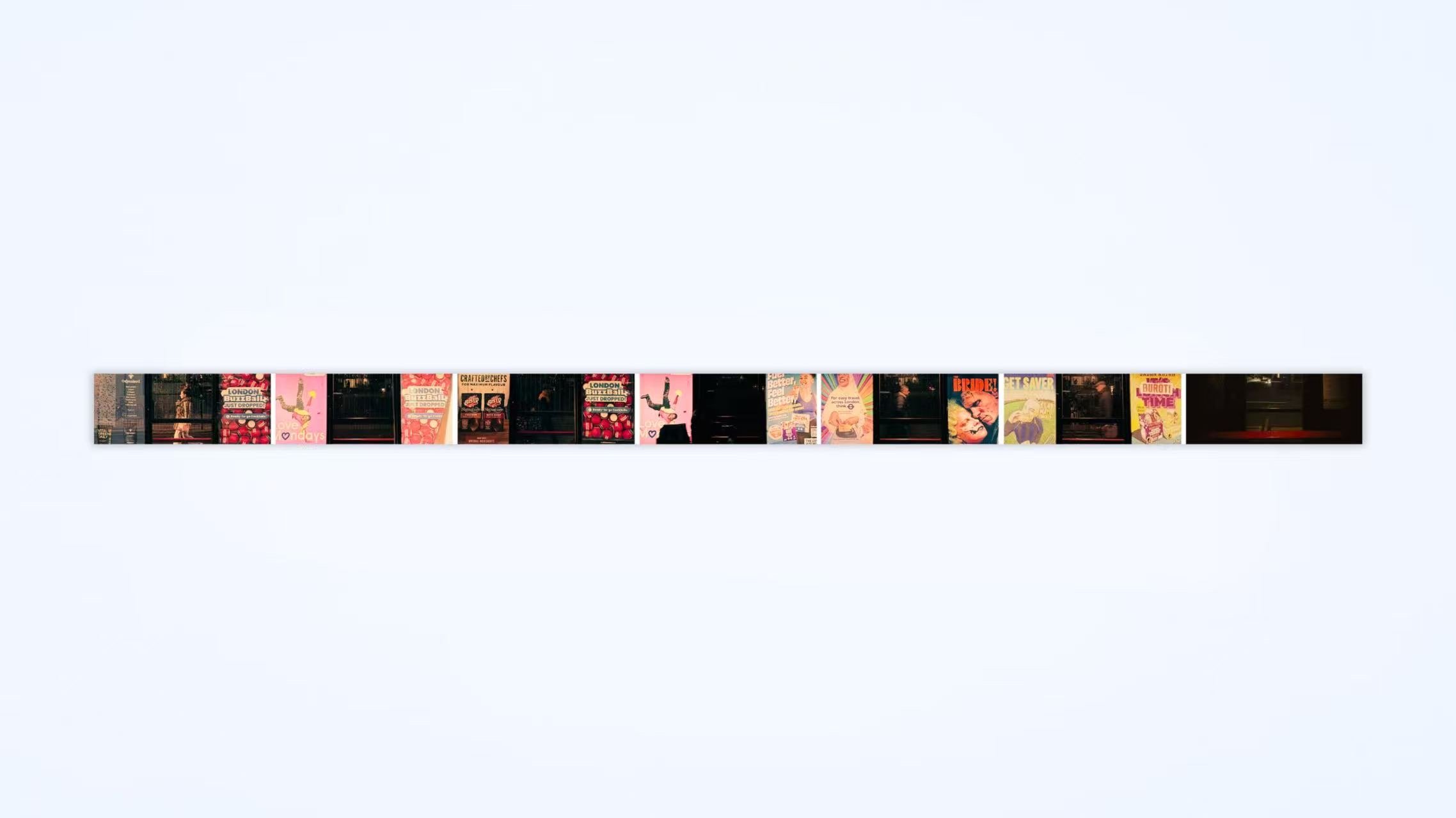 A narrow strip of posters on a vertical surface, featuring various colorful advertisements and images.