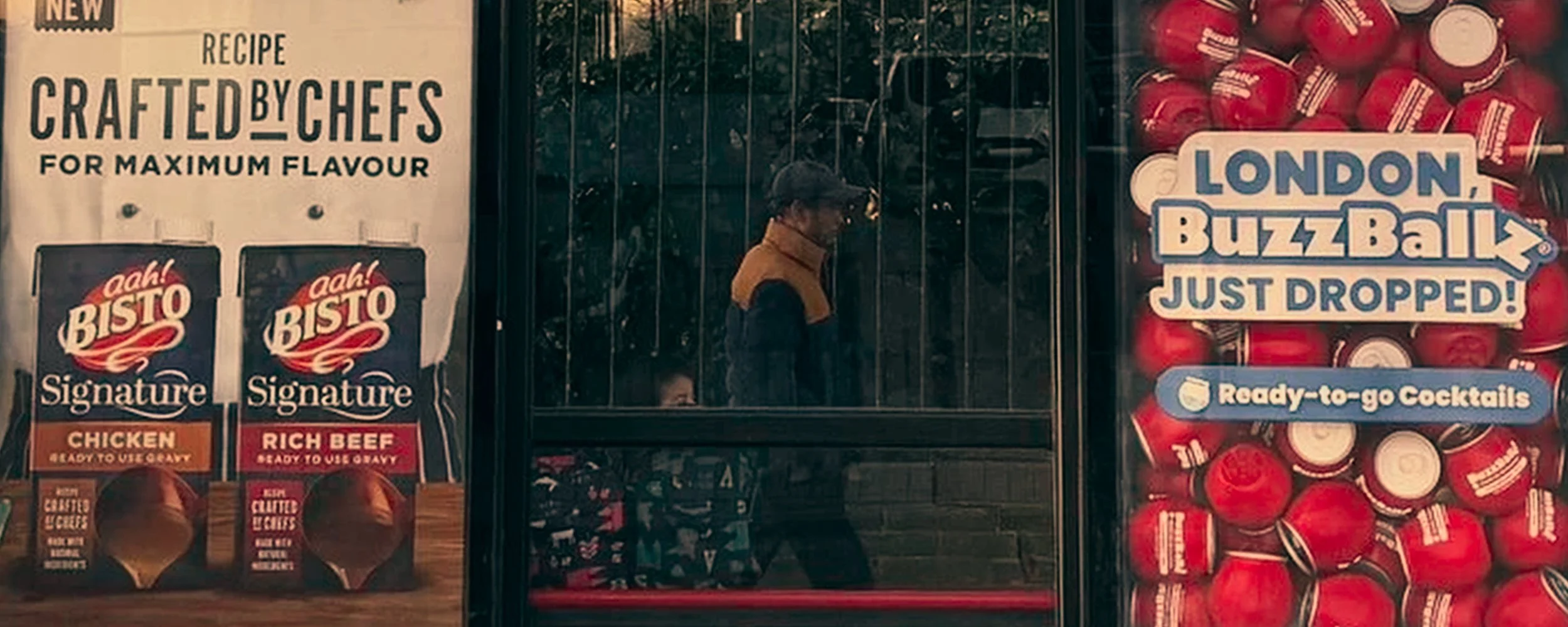 A man walks past vending machines outside a store, with one machine displaying London BuzzBallz cocktails that have just been dropped.