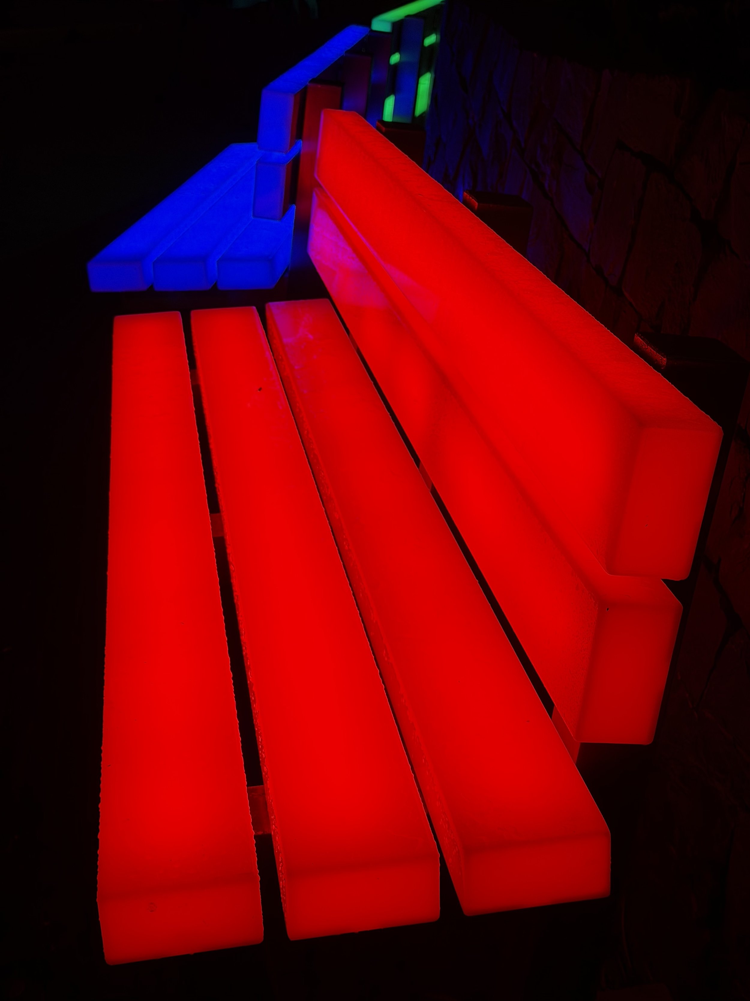 Colorful illuminated furniture in a dark setting, including red, blue, and green lights.
