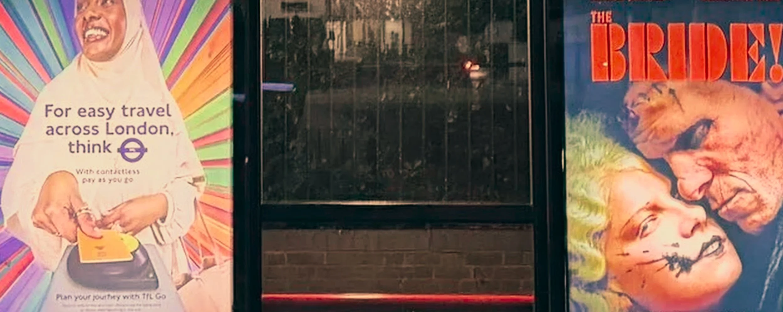 A bus stop with colorful advertisements: on the left, a poster with a woman in hijab holding a travel card, promoting easy travel across London with the Transport for London Oyster card; on the right, a poster for the movie 'The Brides' featuring a c