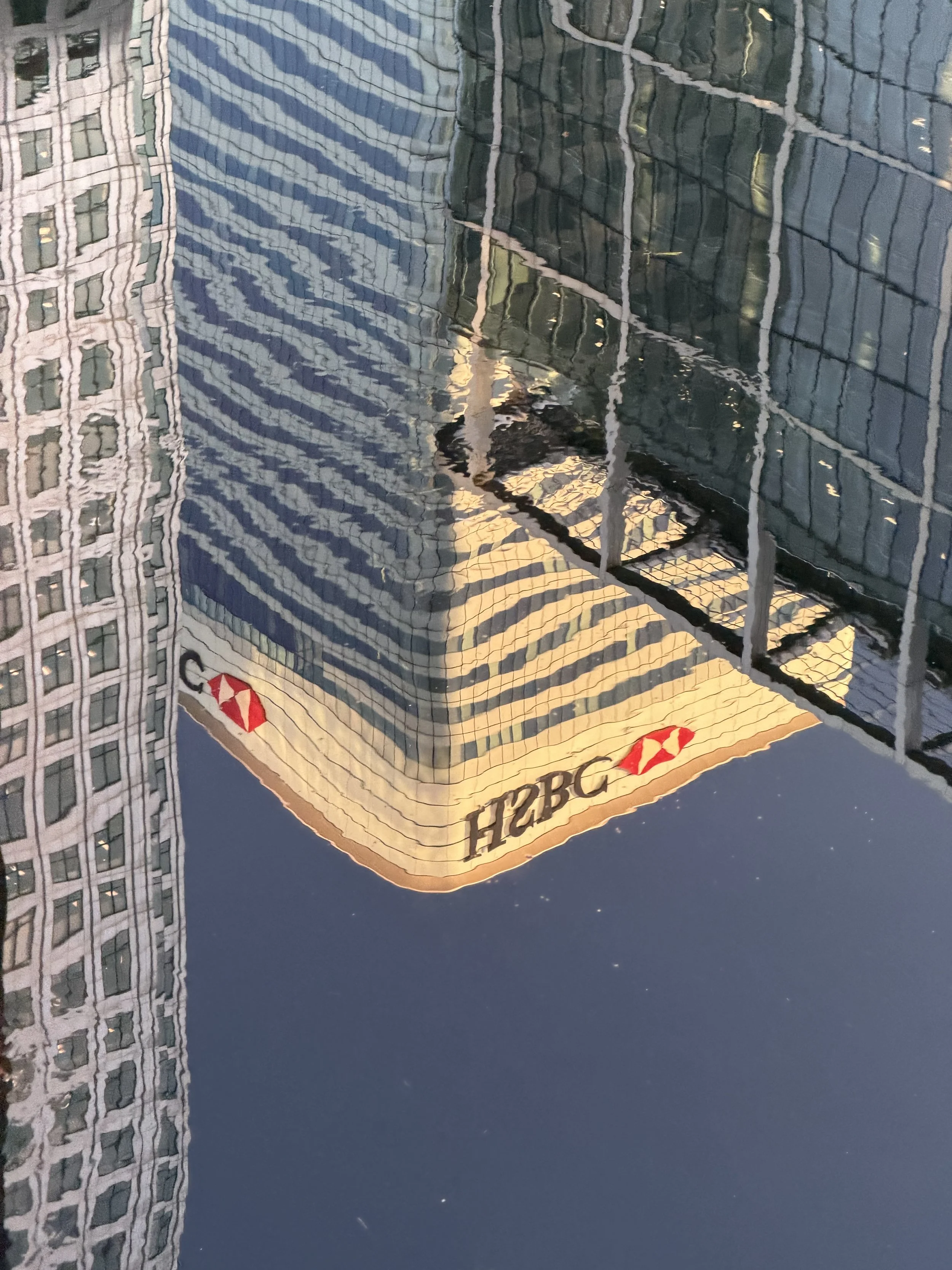 Reflection of tall modern glass buildings in a pool of water