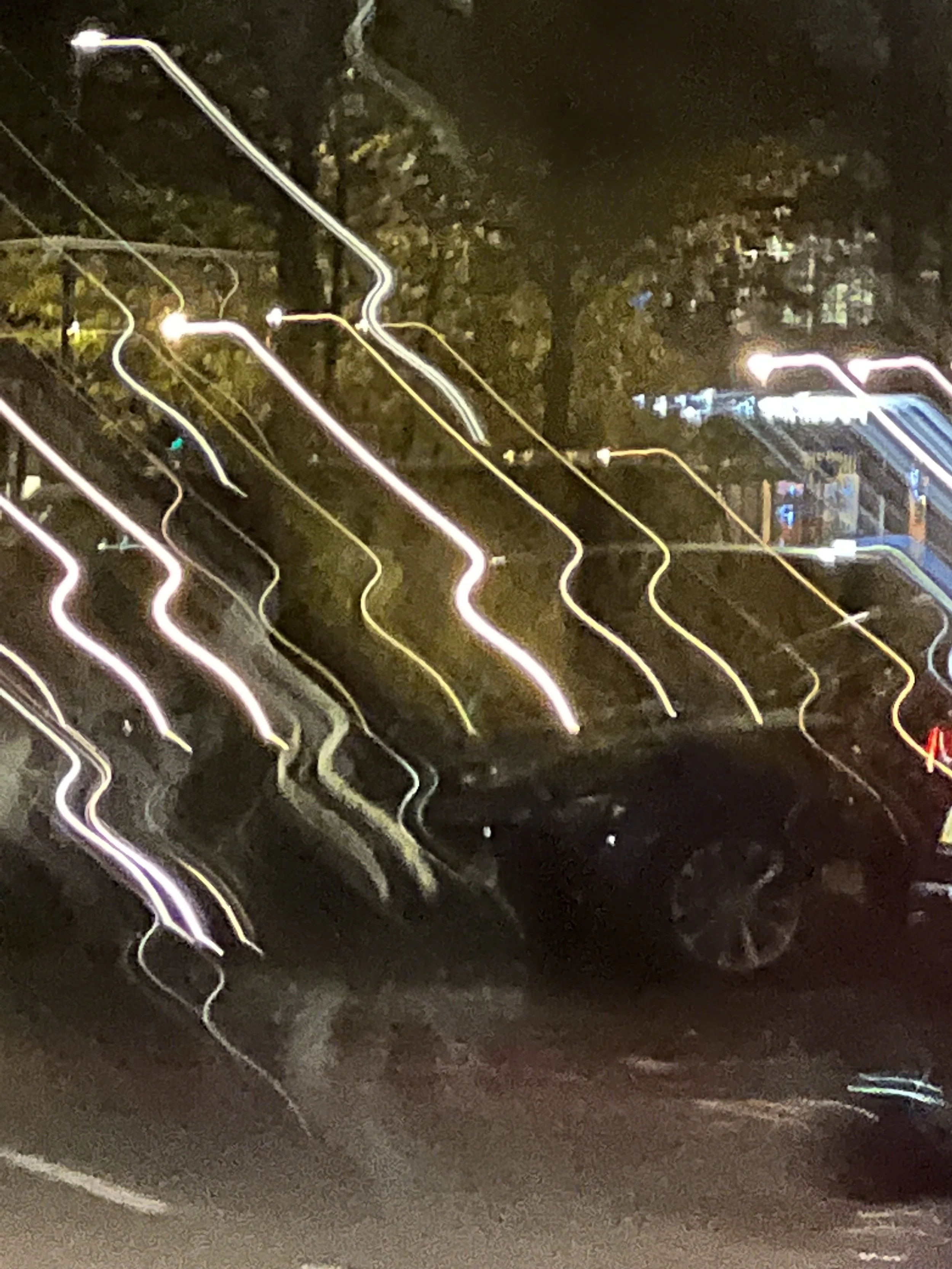 Light trails on a dark road at night, possibly caused by moving lights or long exposure photography.