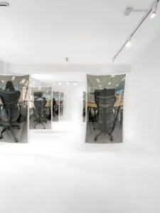 Modern office space with glass walls and chairs.
