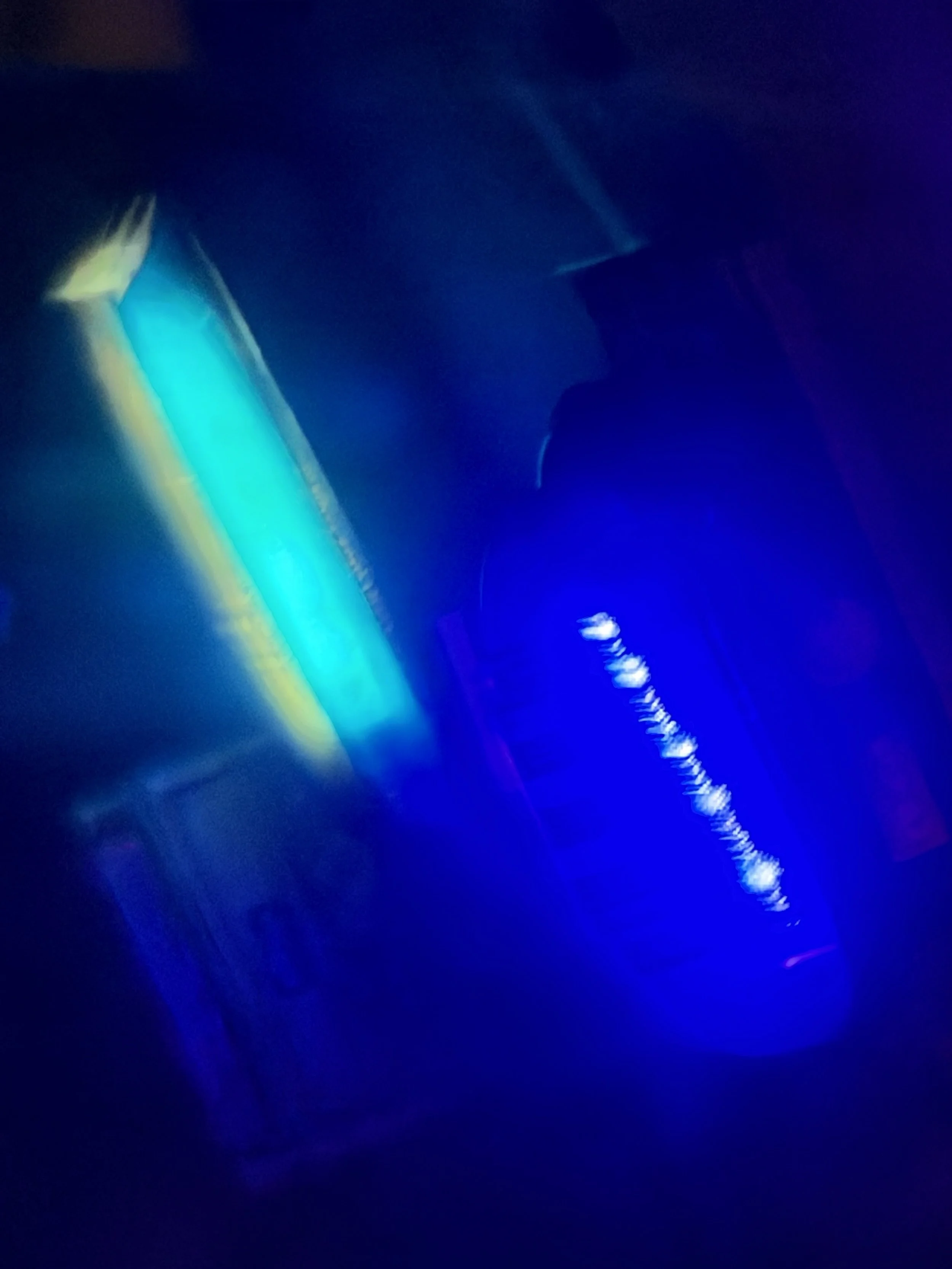 Abstract image with bright streaks of blue, yellow, and purple light against a dark background.