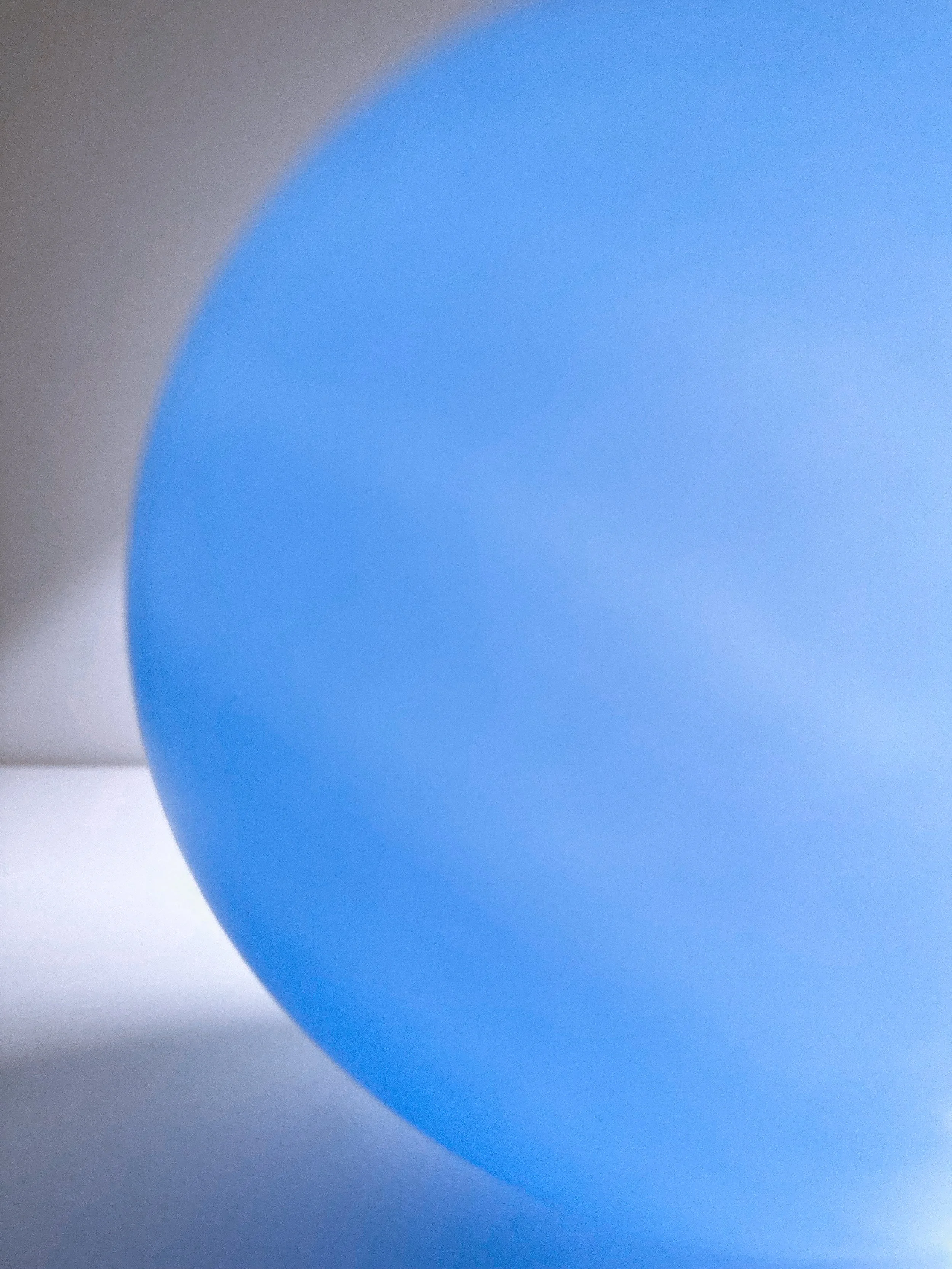Close-up of a blue balloon against a white background.