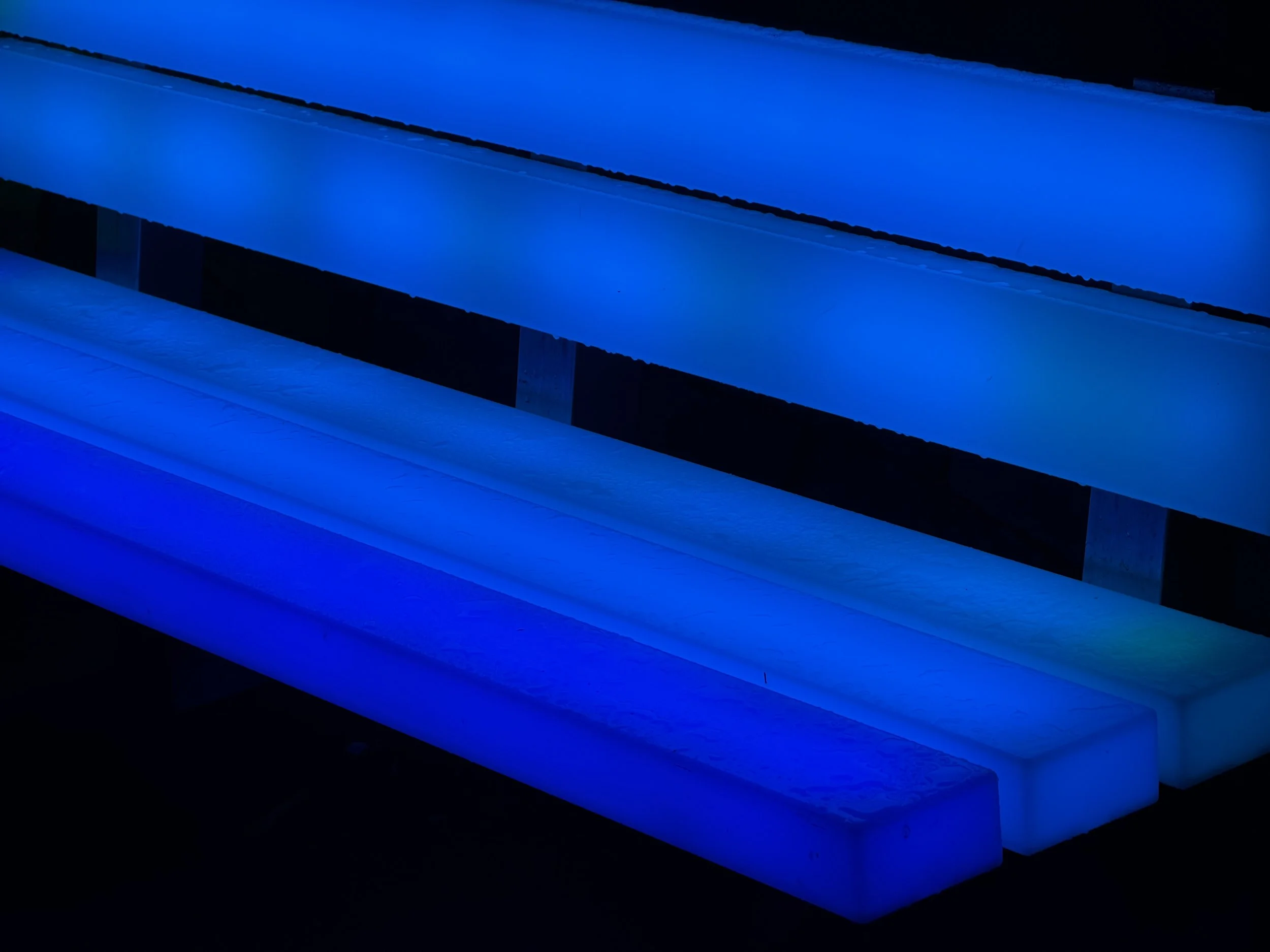 Image of stairs illuminated with blue lights in a dark environment.