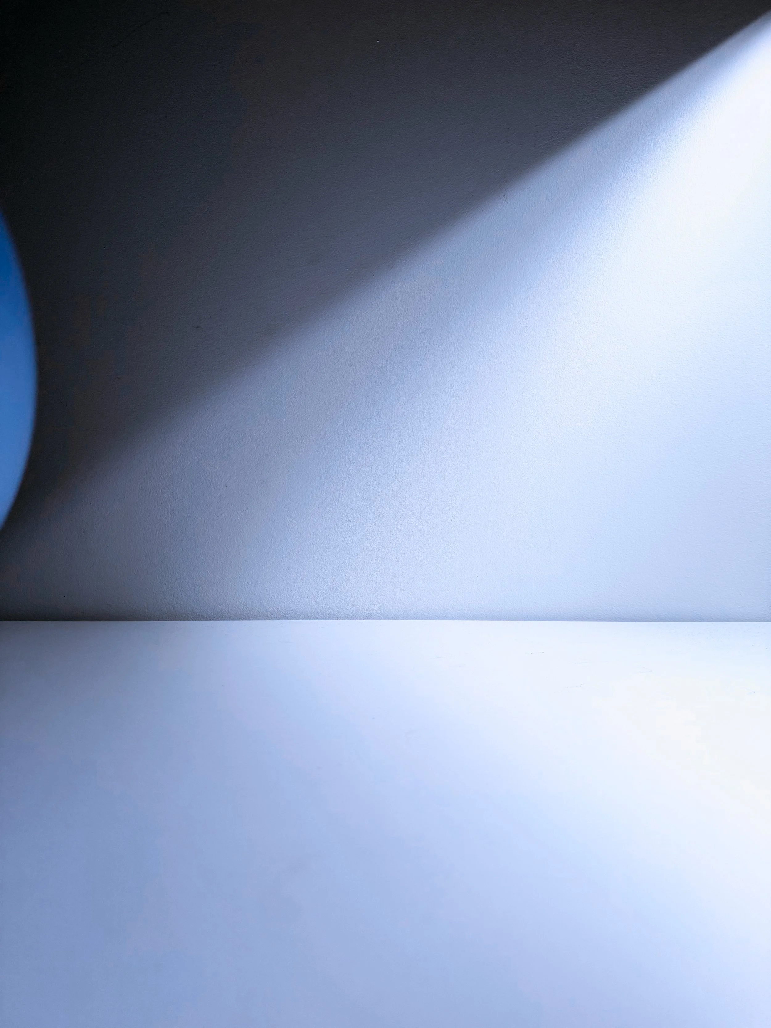 Close-up of a wall with shadow and light creating a gradient effect.