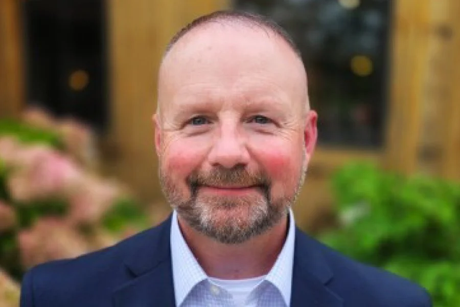 Headshot of Zac House, standing outdoors, smiling