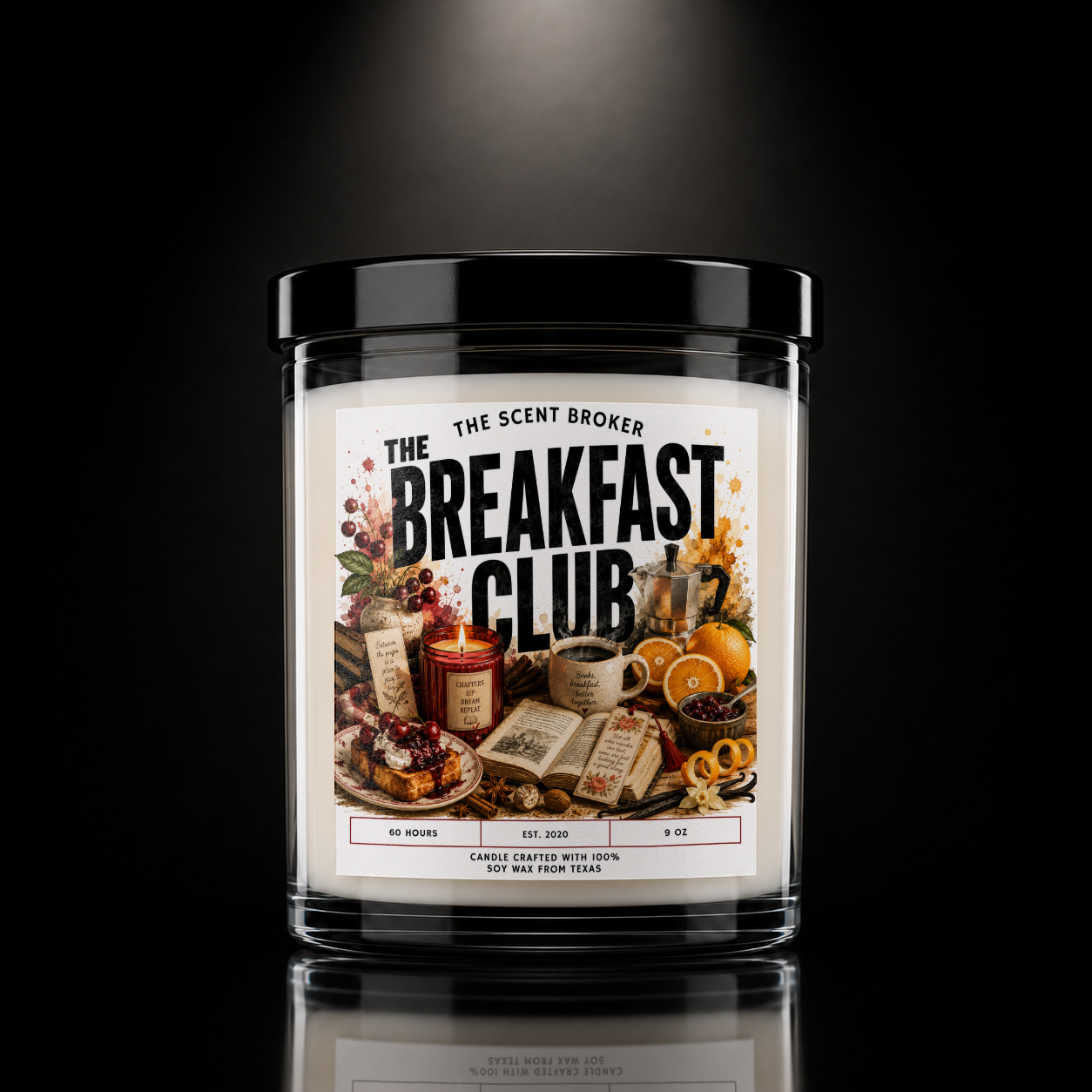 Scented candle labeled 'Breakfast Club' with decorative breakfast items like oranges, coffee, books, and spices against a dark background.