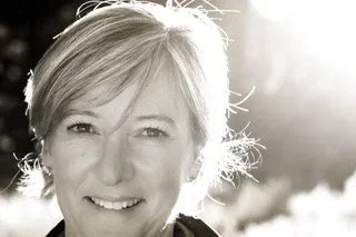 Close-up of a woman smiling outdoors in sunlight