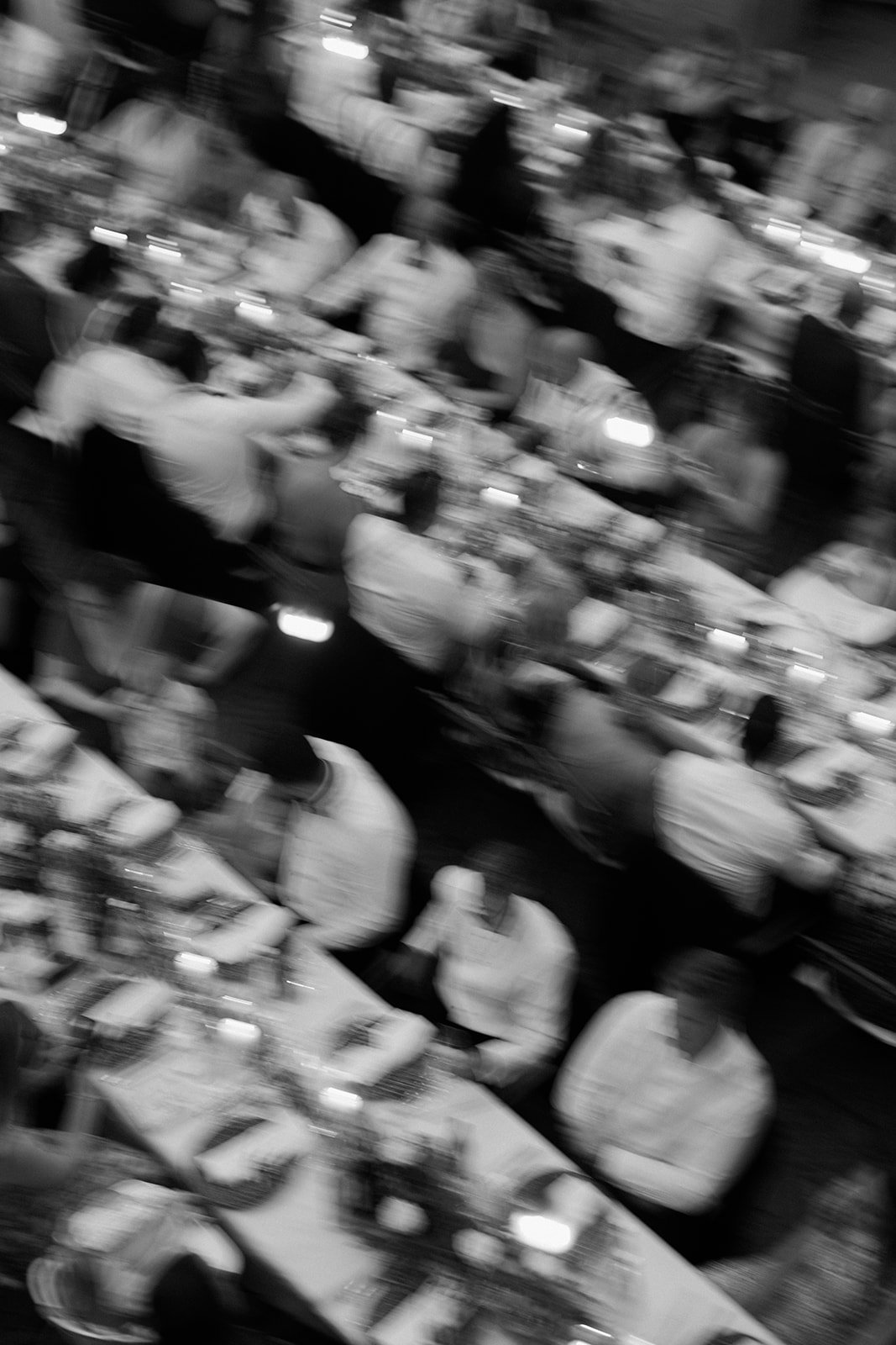 Blurry black and white film photo of a wedding reception.