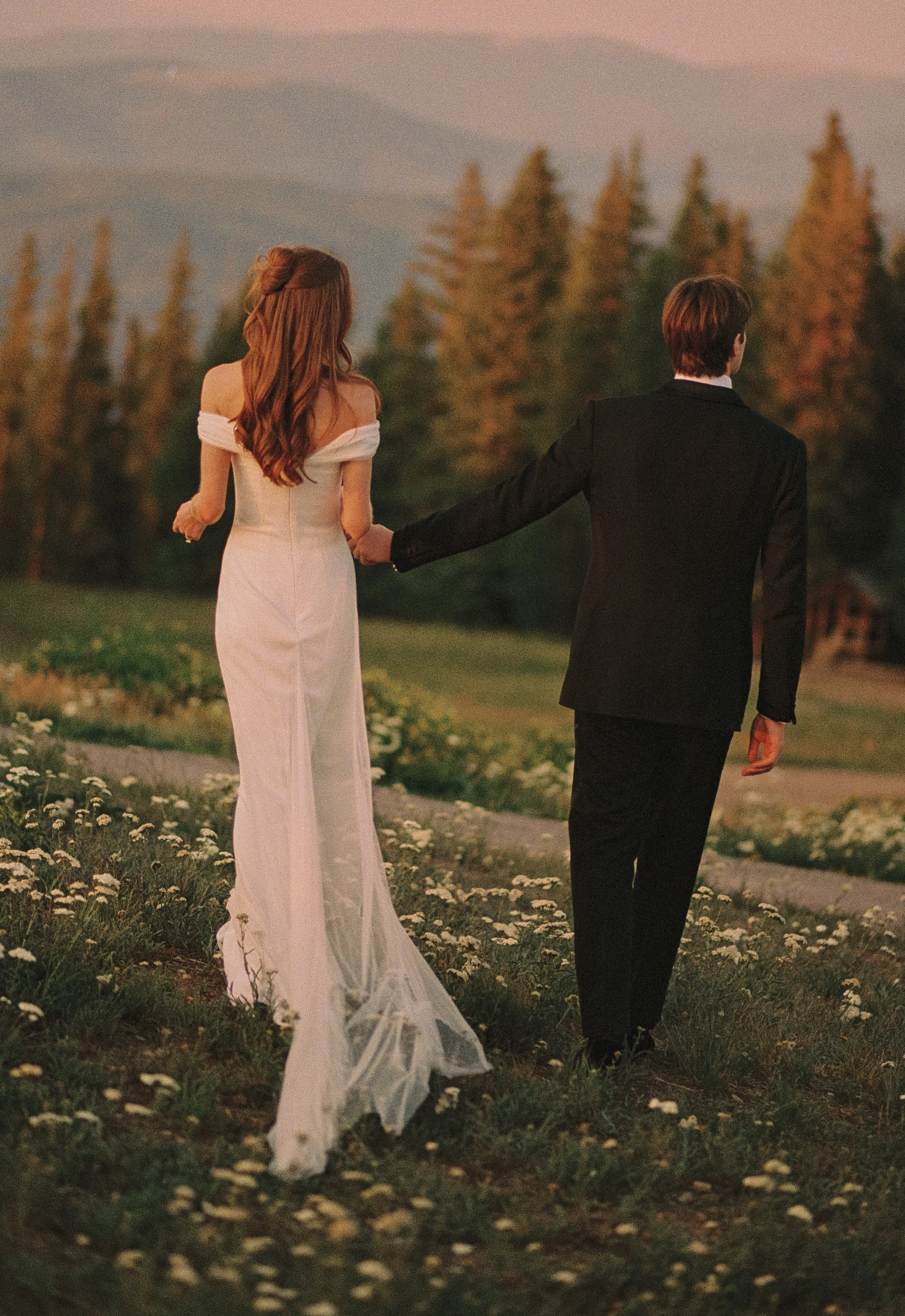 A film portrait of an Aspen bride and groom walking in front of the gondola at the Aspen Sundeck.