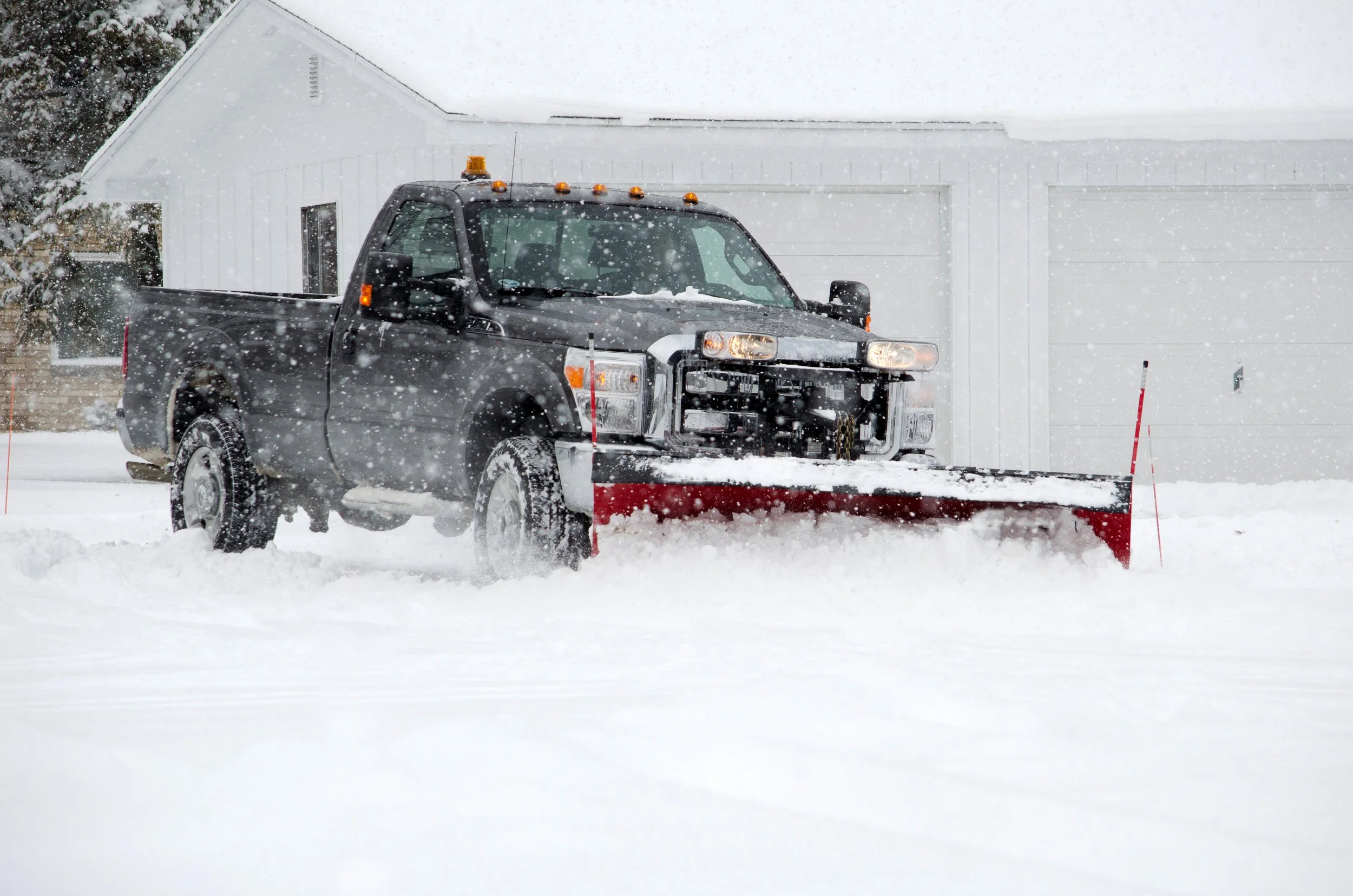 A snow plow truck plowing snow in the streets in Bozeman Montana