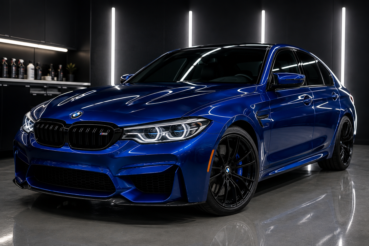 A blue BMW M3 sports car parked inside a modern garage with sleek black walls and bright vertical lighting.