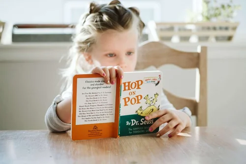 A child holding the book Hop on Pop