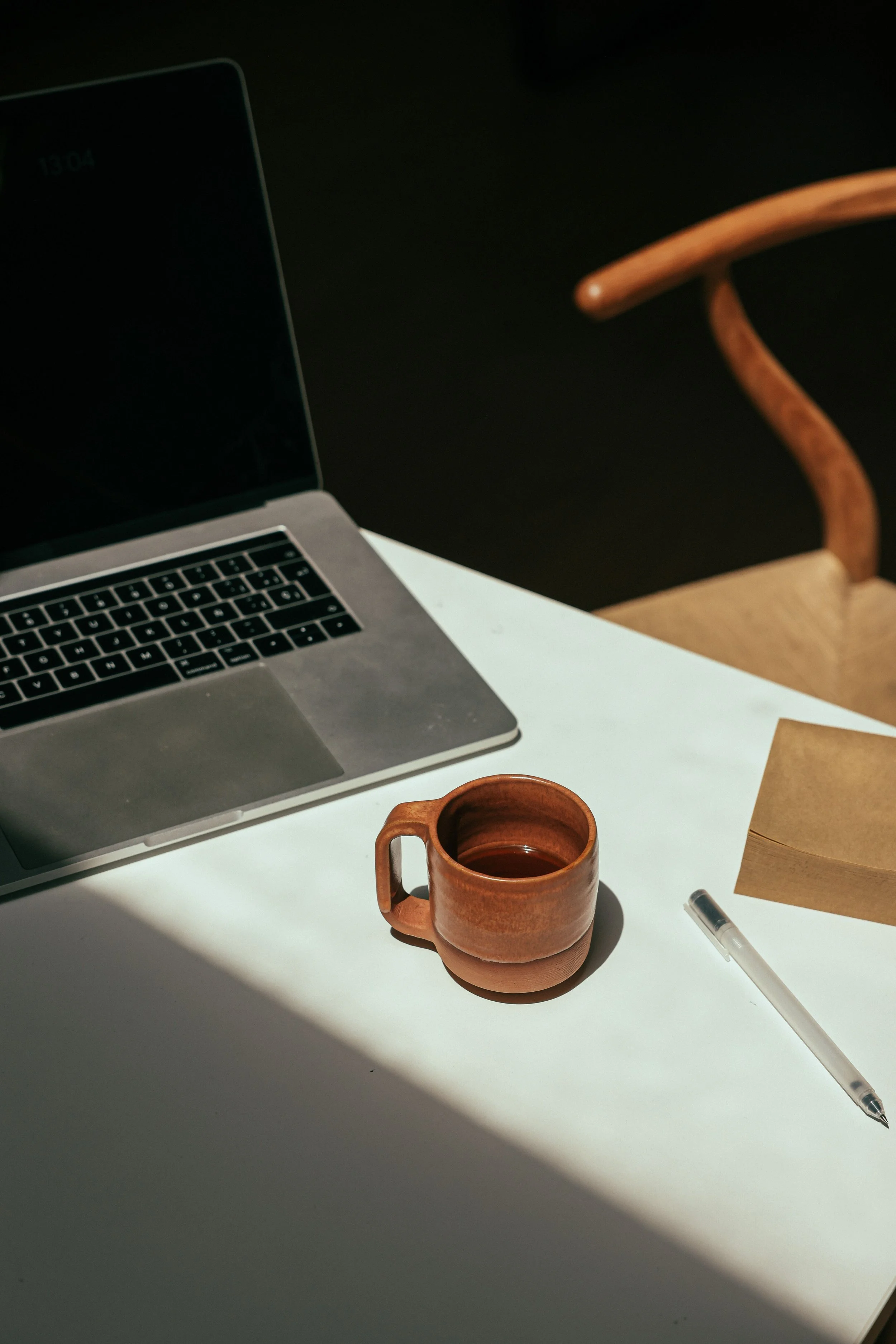 Open laptop with a cup of coffee next to it