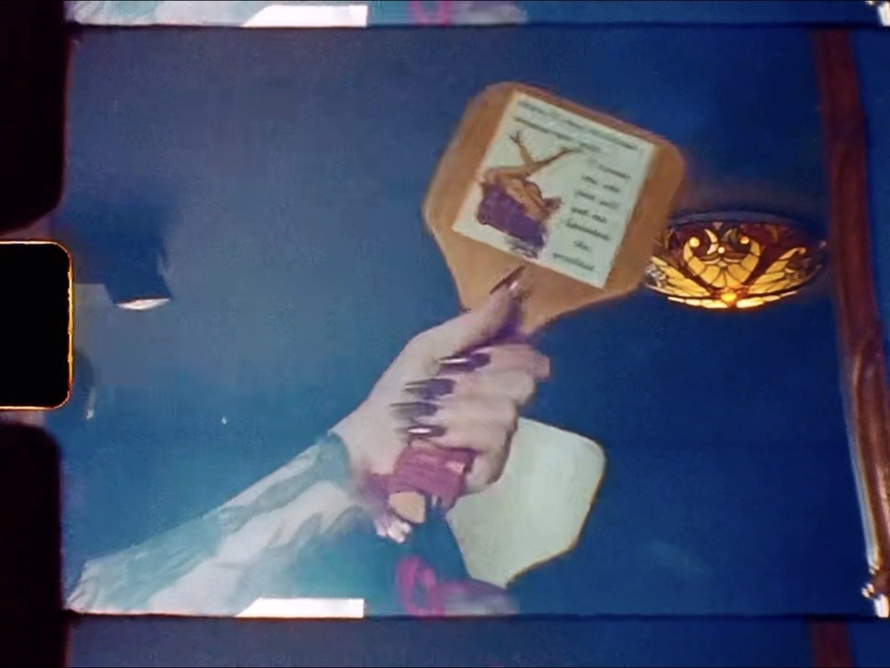 A hand holding a hammer hitting a box with a picture of a deer and a purple object on a blue background.