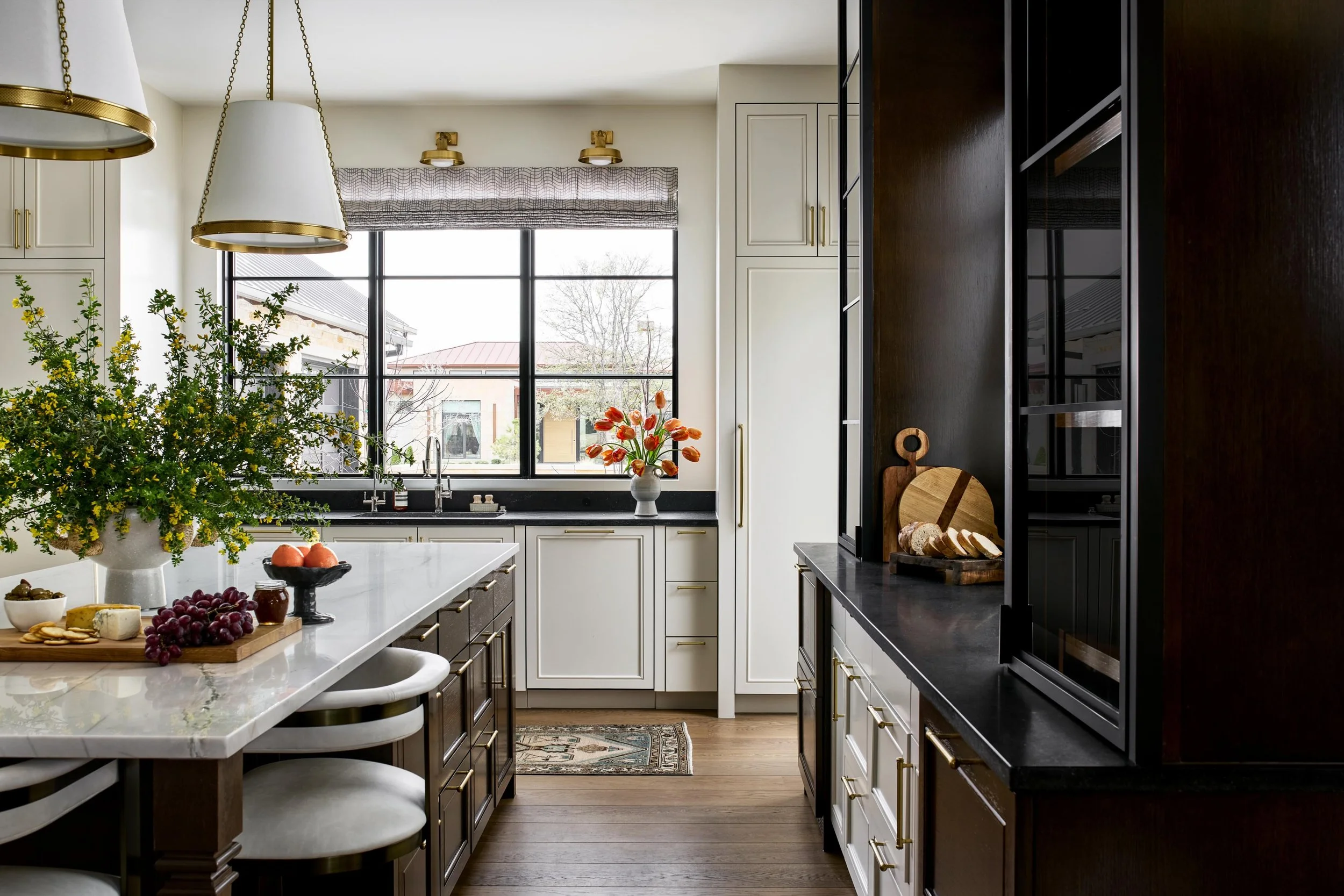 Warm wood tones, creamy cabinetry, unlacquered brass and beautiful stone 🤍 We love a space that feels warm, inviting and anything but boring. This one checks all the boxes ☑️☑️☑️

Design: @lark.interiors
Photography: @stacyzaringoldberg 
Floral: @wh