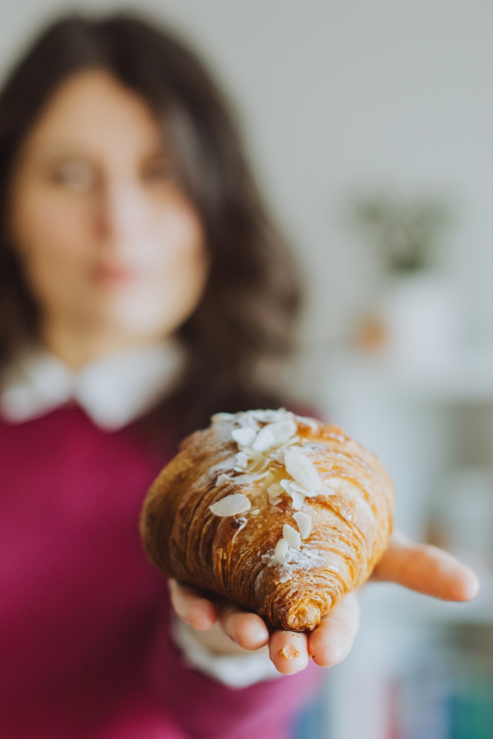 copy-corner-blog-how-to-market-your-health-wellness-business-without-social-media-patricia-holding-a-croissant-in-front-of-her