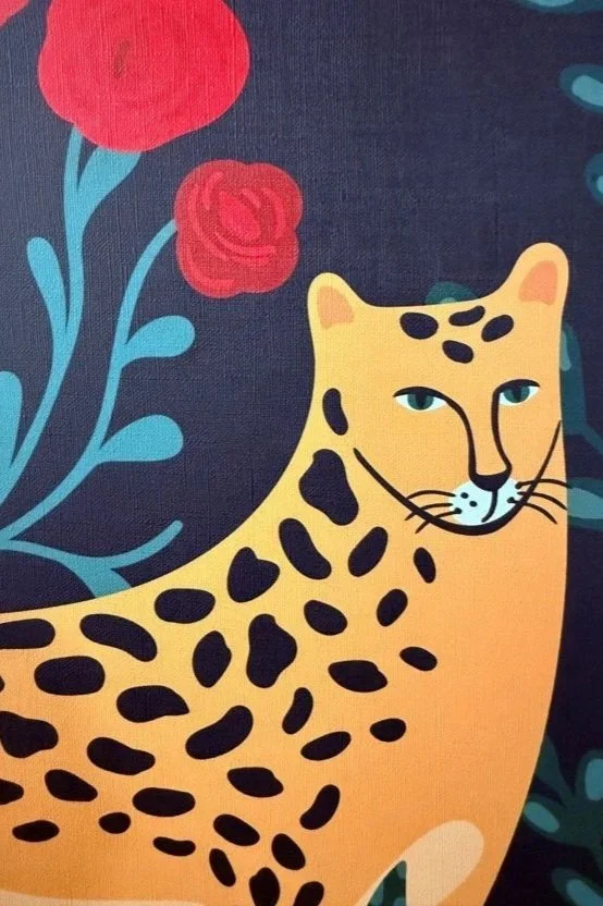 Illustration of a stylized yellow leopard with black spots, set against a dark background with red flowers and blue leaves.