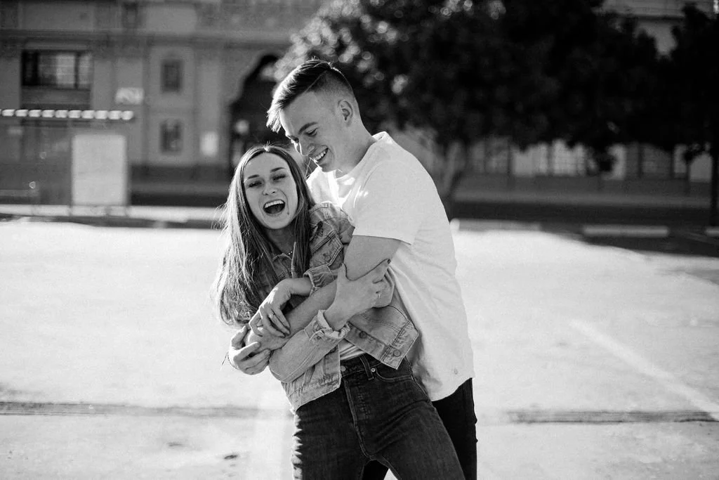 Eric and Sarah Brooks, the owners of Brooks Photo + Video. Give each other a hug during a portrait session.