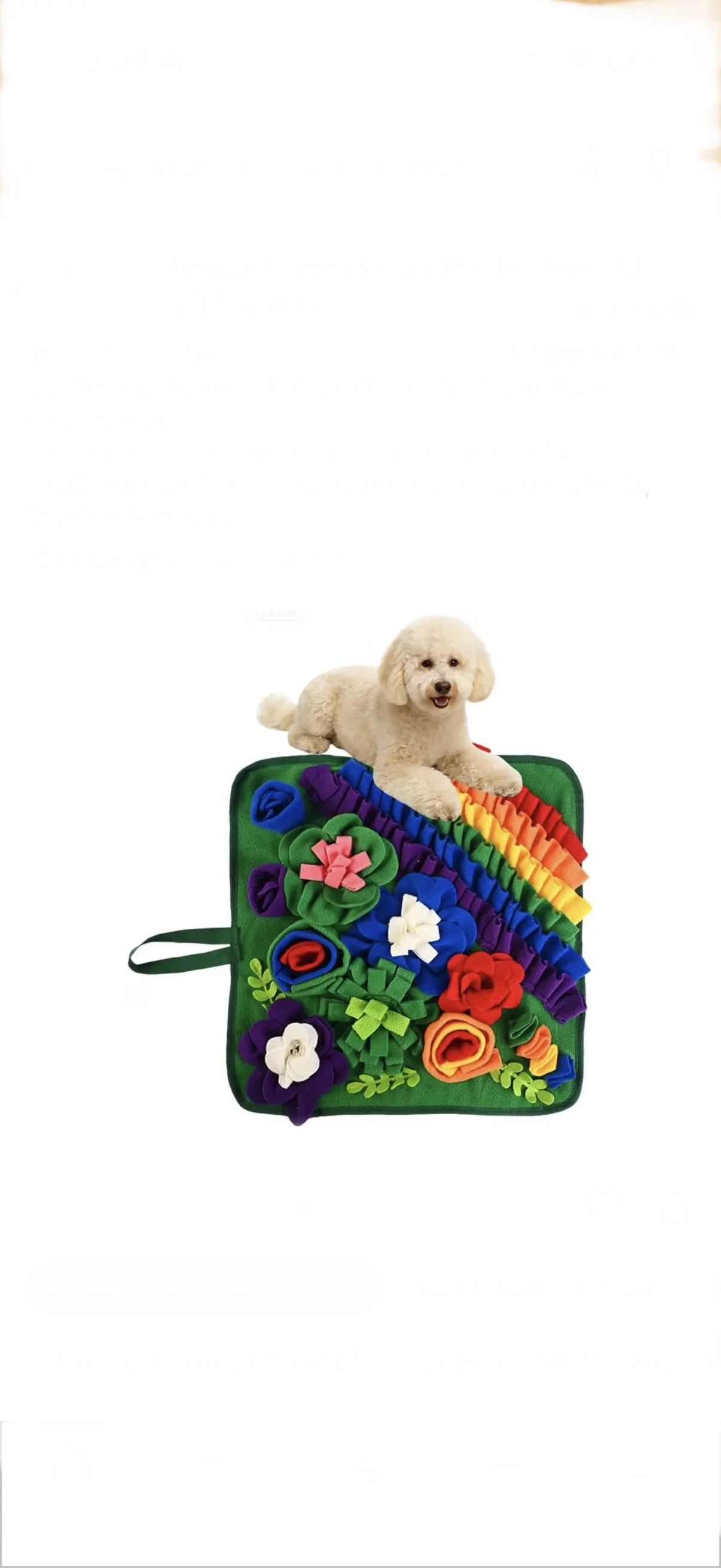 A small white dog lying on a colorful felt flower craft displayed on a green mat.