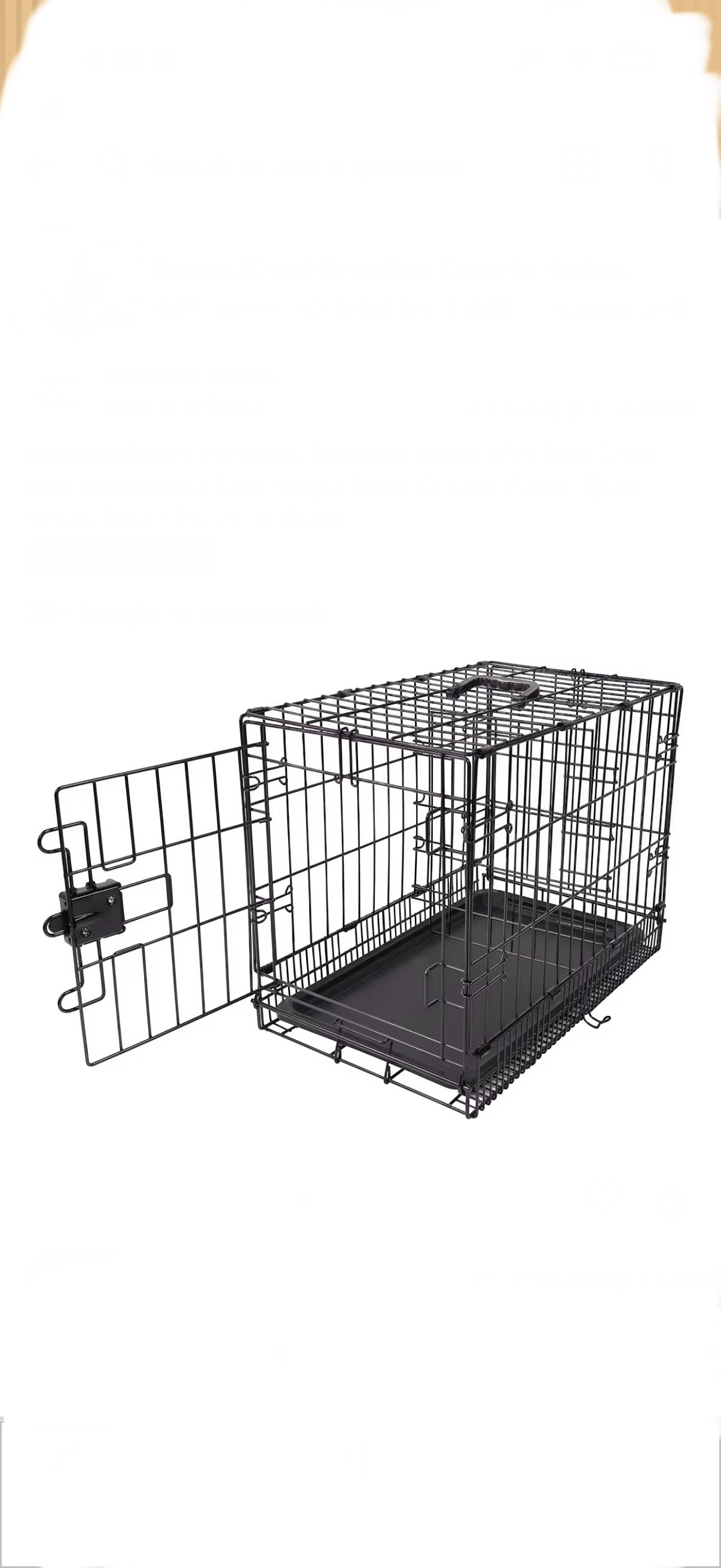 Black metal dog crate with an open door and a pull-out plastic tray at the bottom.