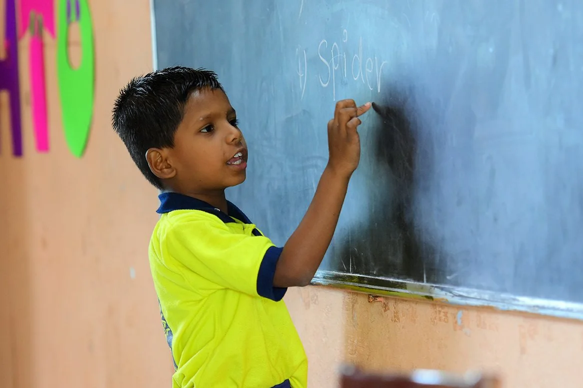 Boy pointing to chalkboard