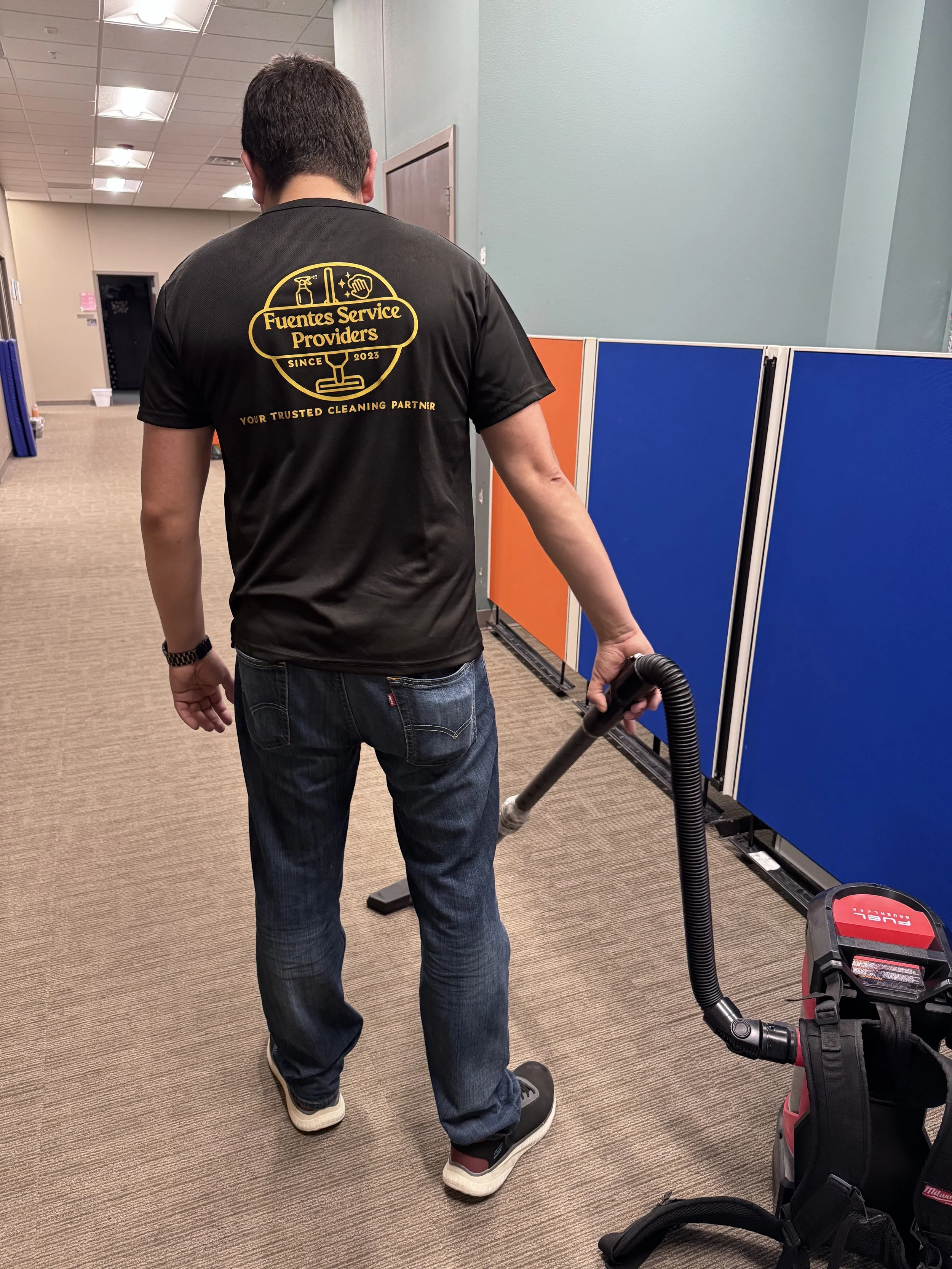 Fuentes Service Providers team member vacuuming an office