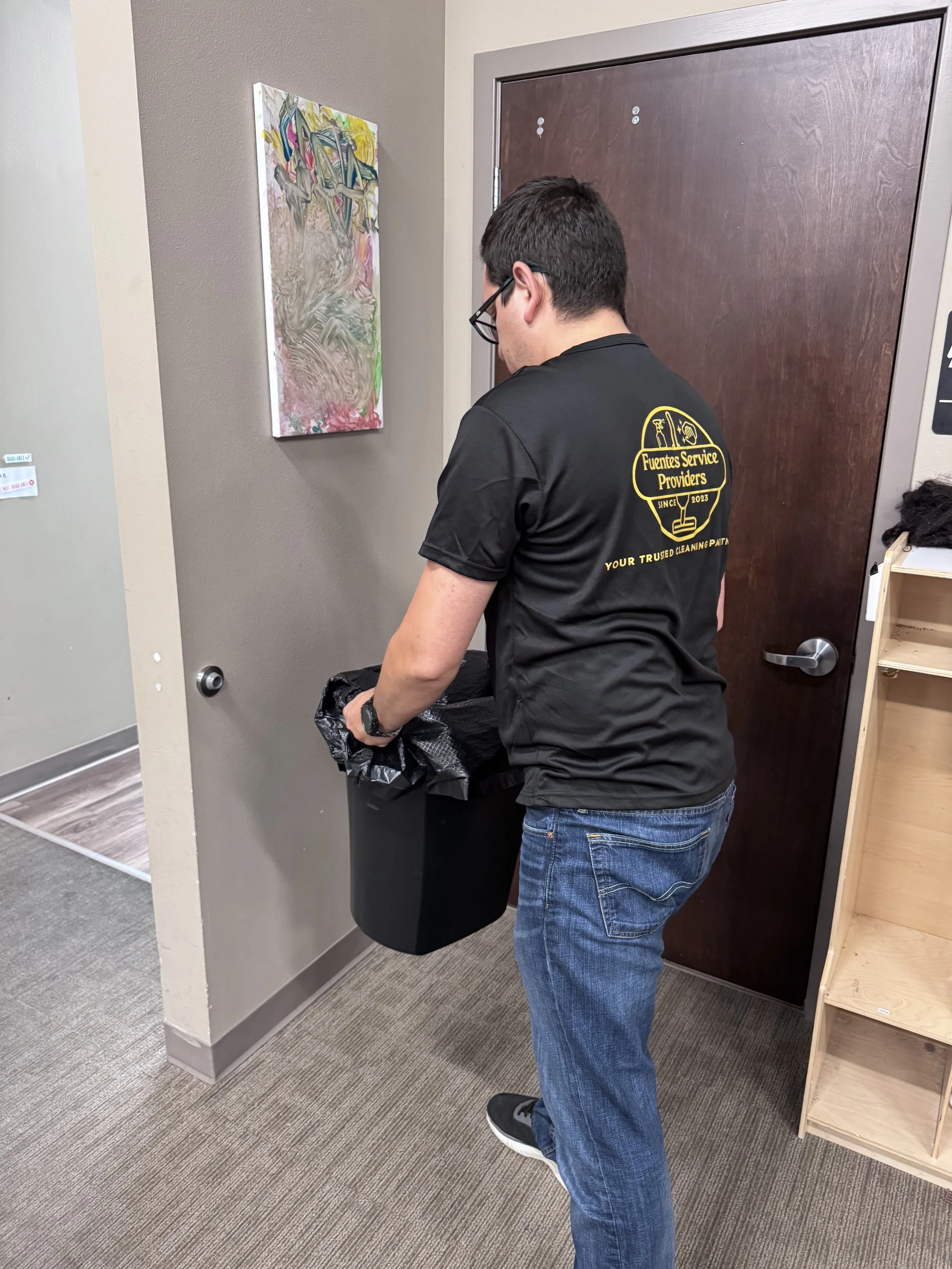Fuentes Service Providers team member emptying an office trash bin